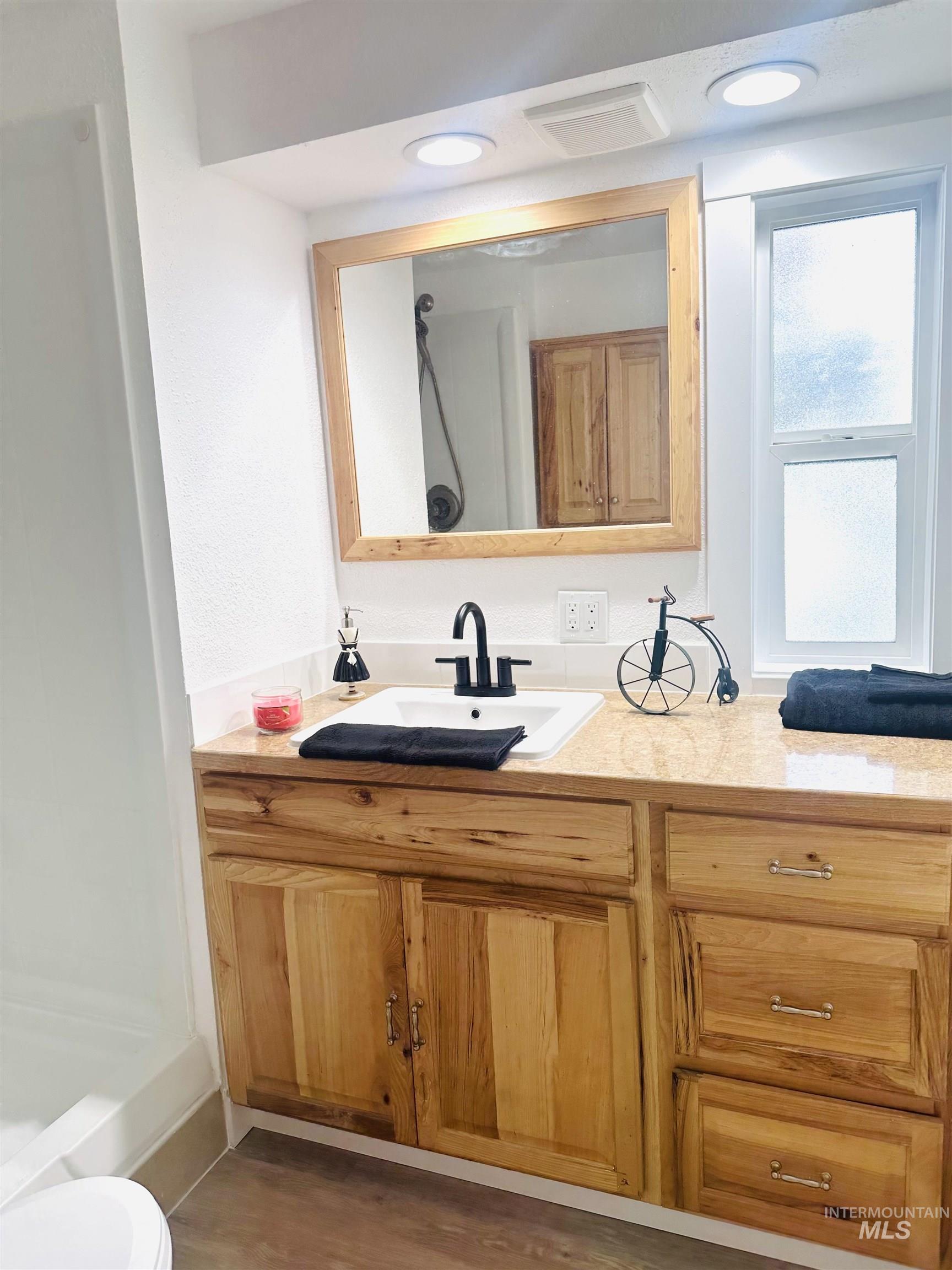 Full bathroom featuring vanity, a shower stall, dark wood-type flooring, and recessed lighting