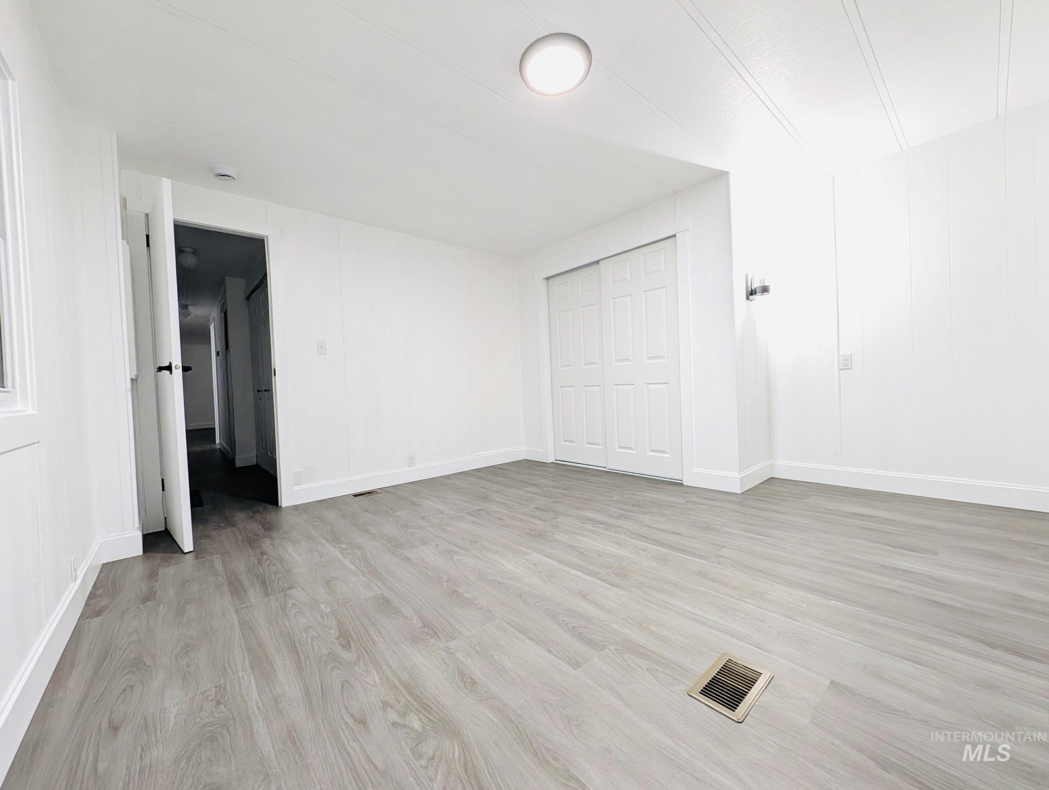 Unfurnished bedroom featuring light wood-type flooring and a closet