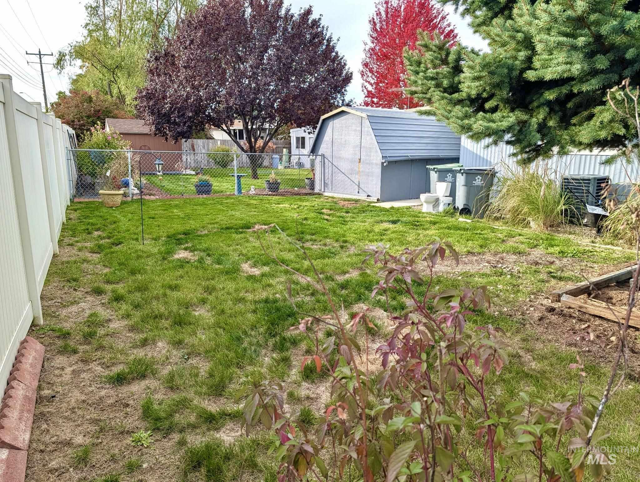 Fenced backyard with a storage unit