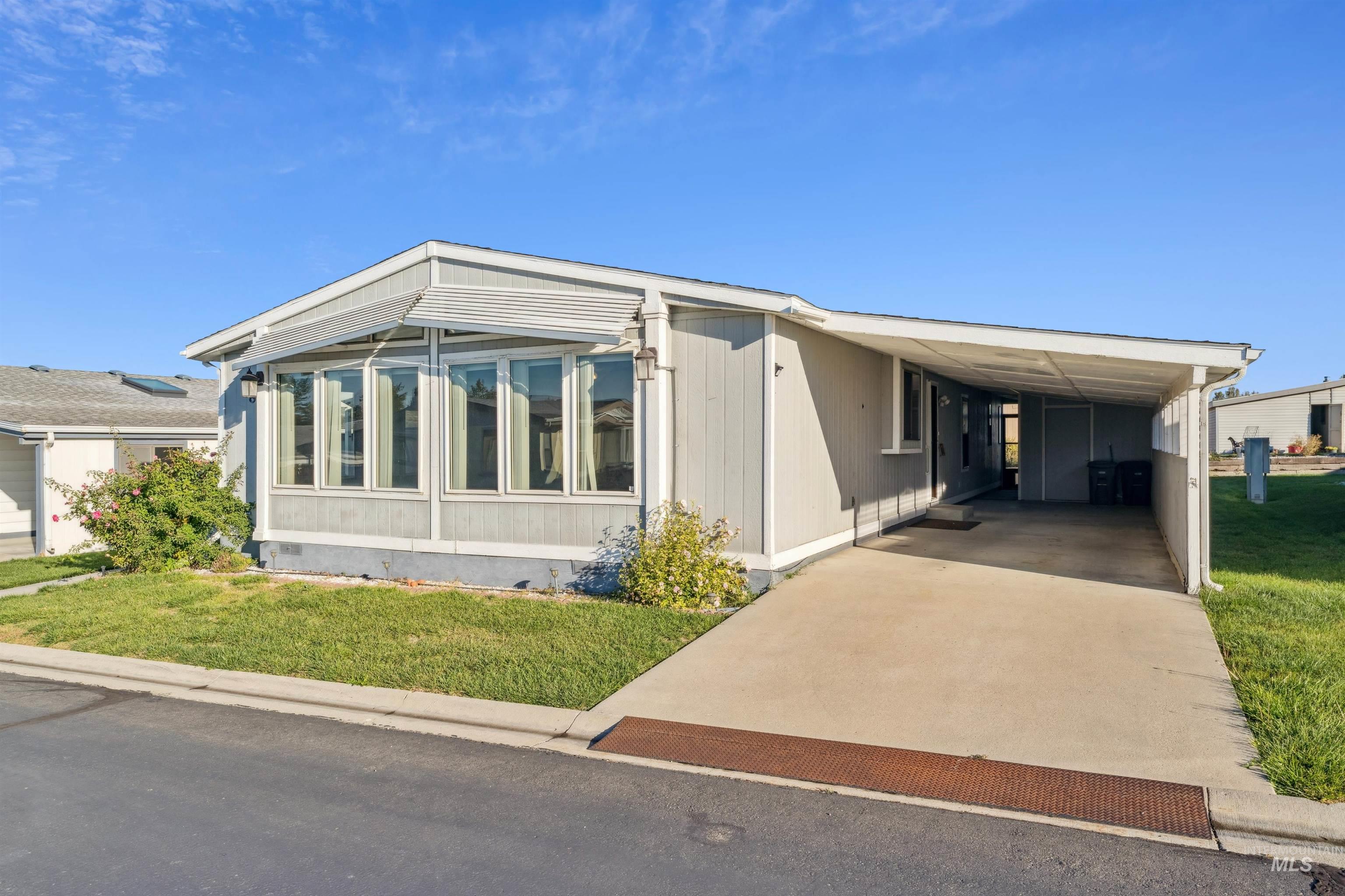 View of front of property featuring a front yard, a carport, and concrete driveway