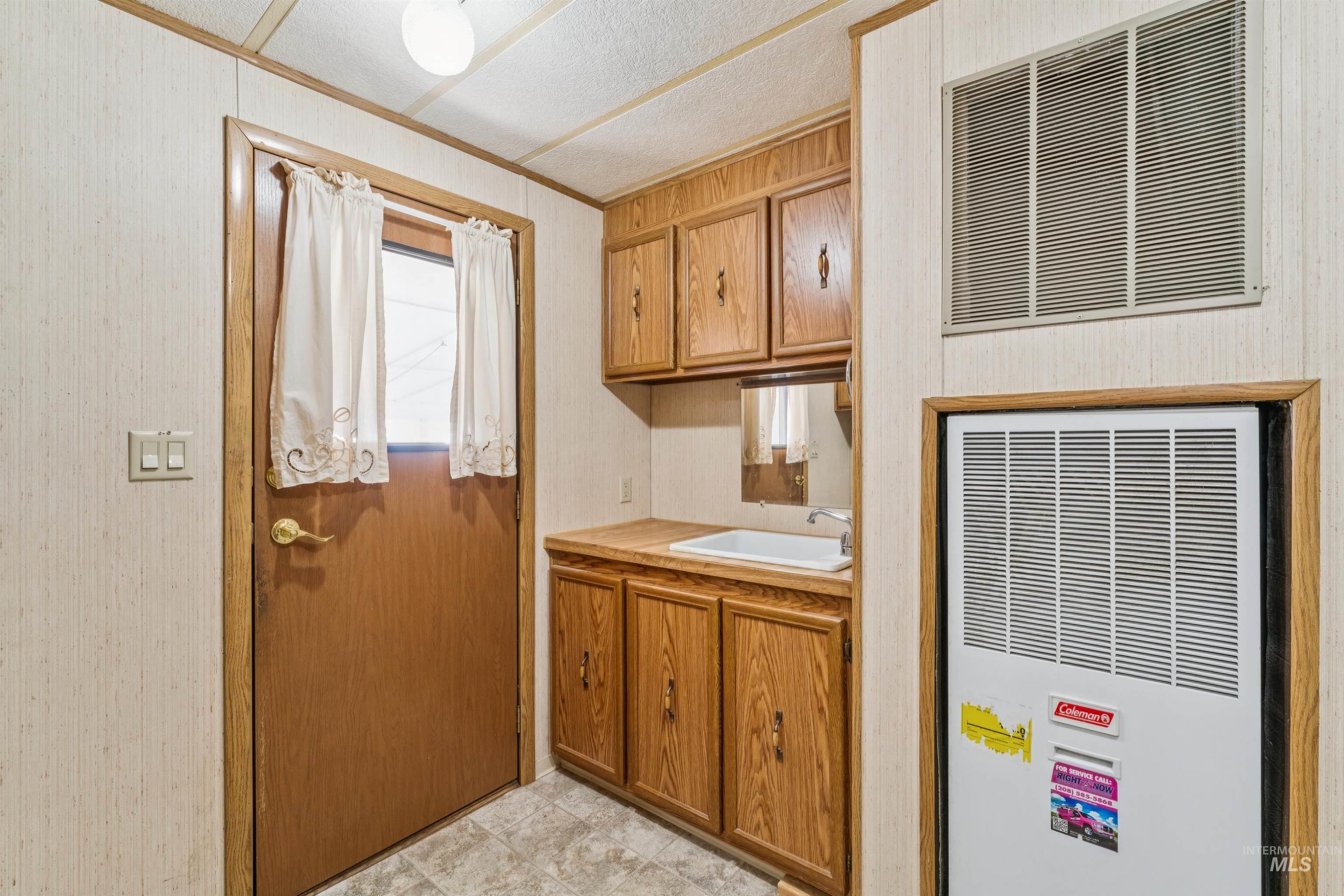 Bathroom featuring a heating unit, vanity, and crown molding