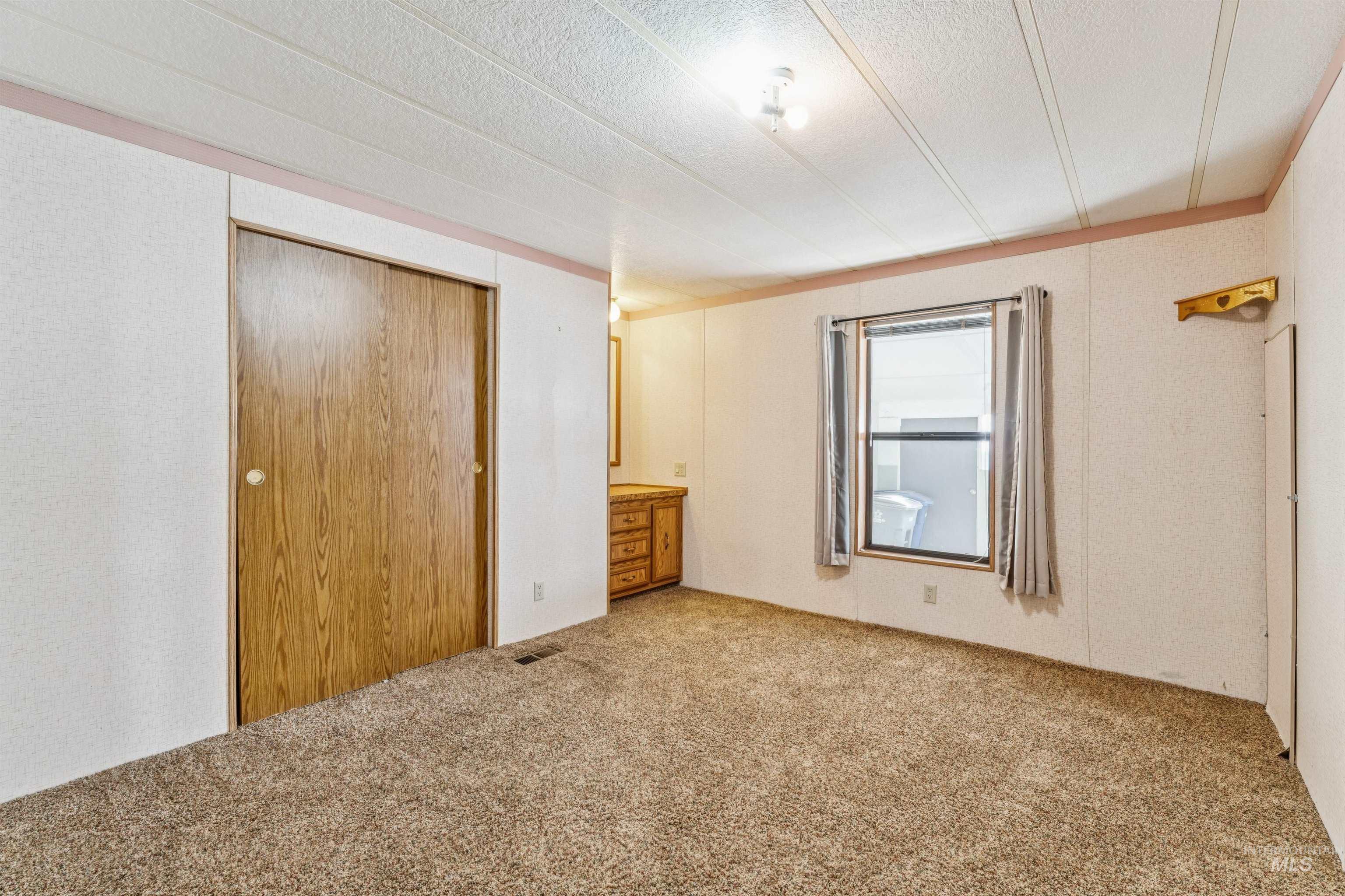 Unfurnished bedroom with carpet, a closet, and a textured ceiling