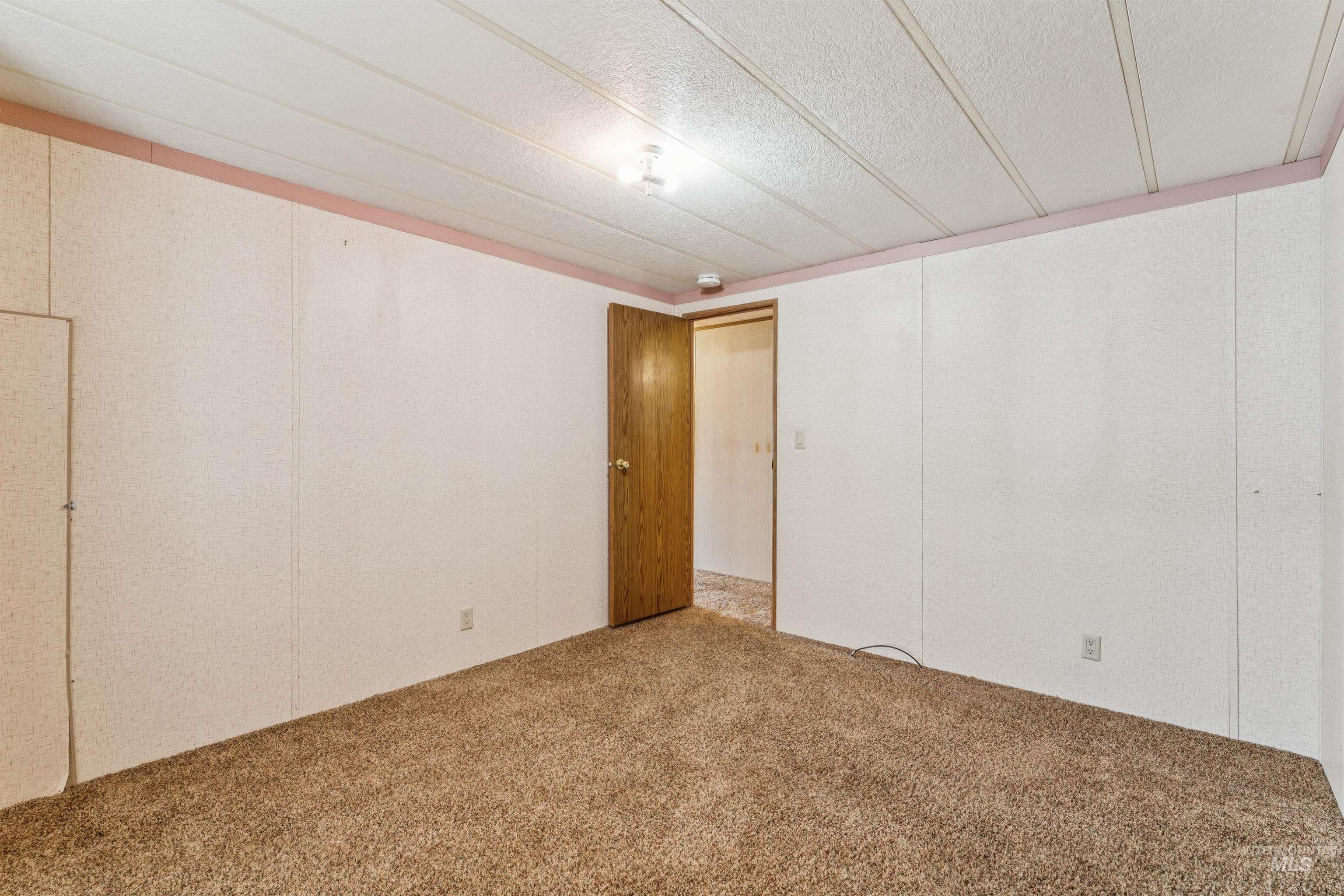 Carpeted spare room with a textured ceiling