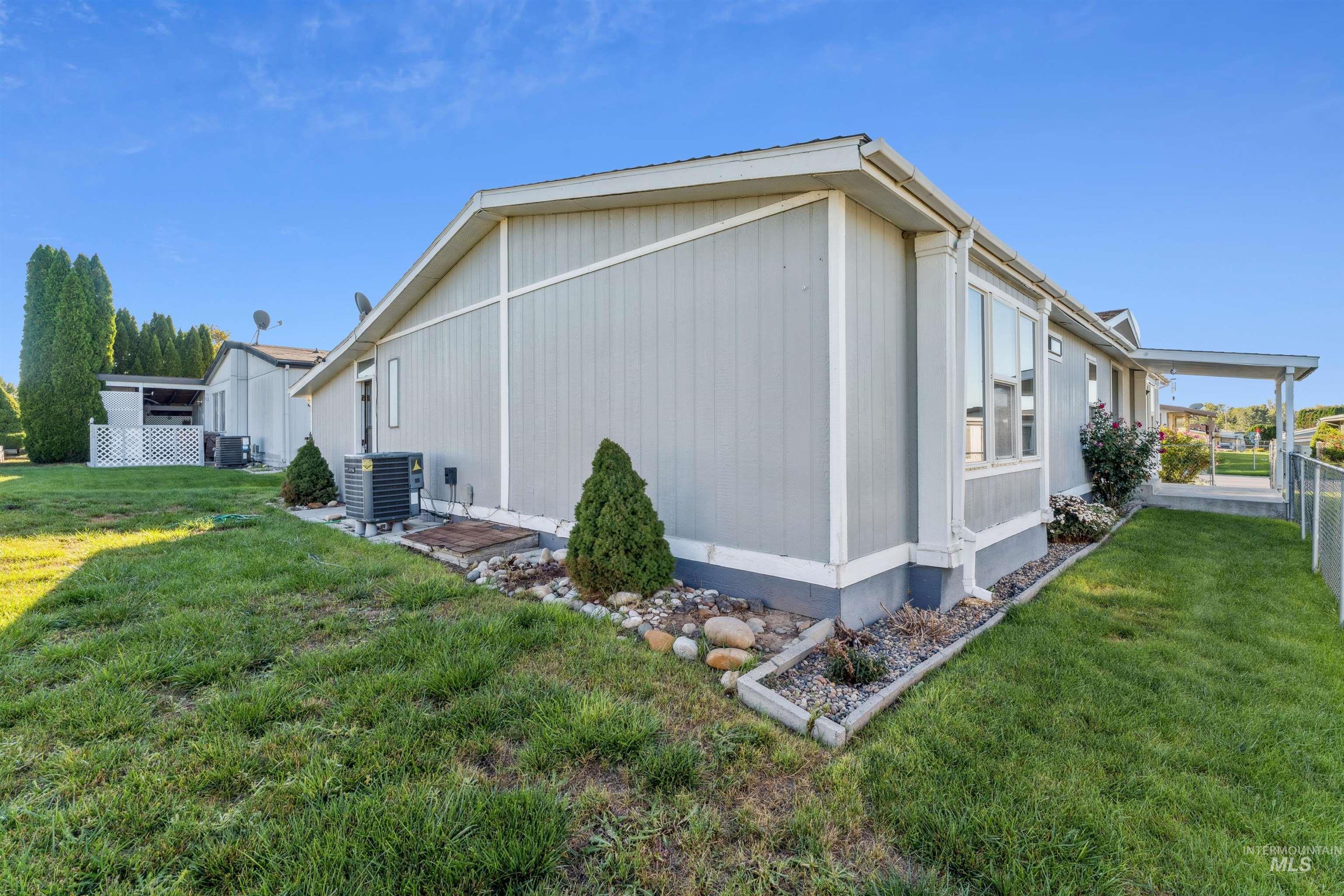 View of property exterior with a yard and a cooling unit
