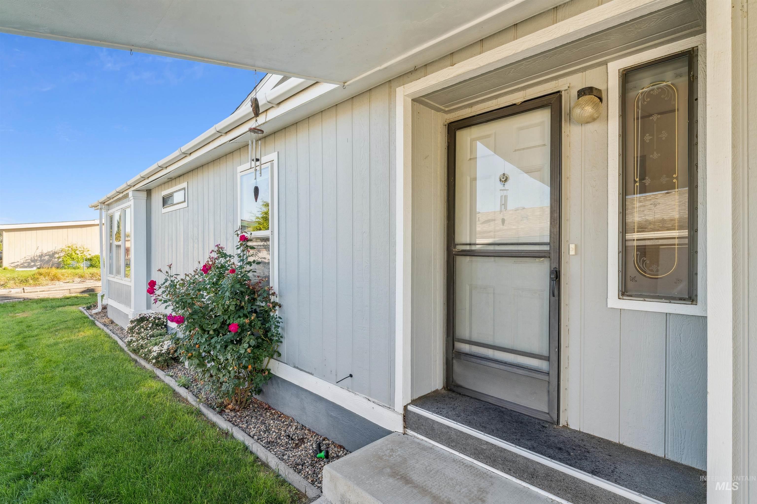 View of exterior entry featuring a yard