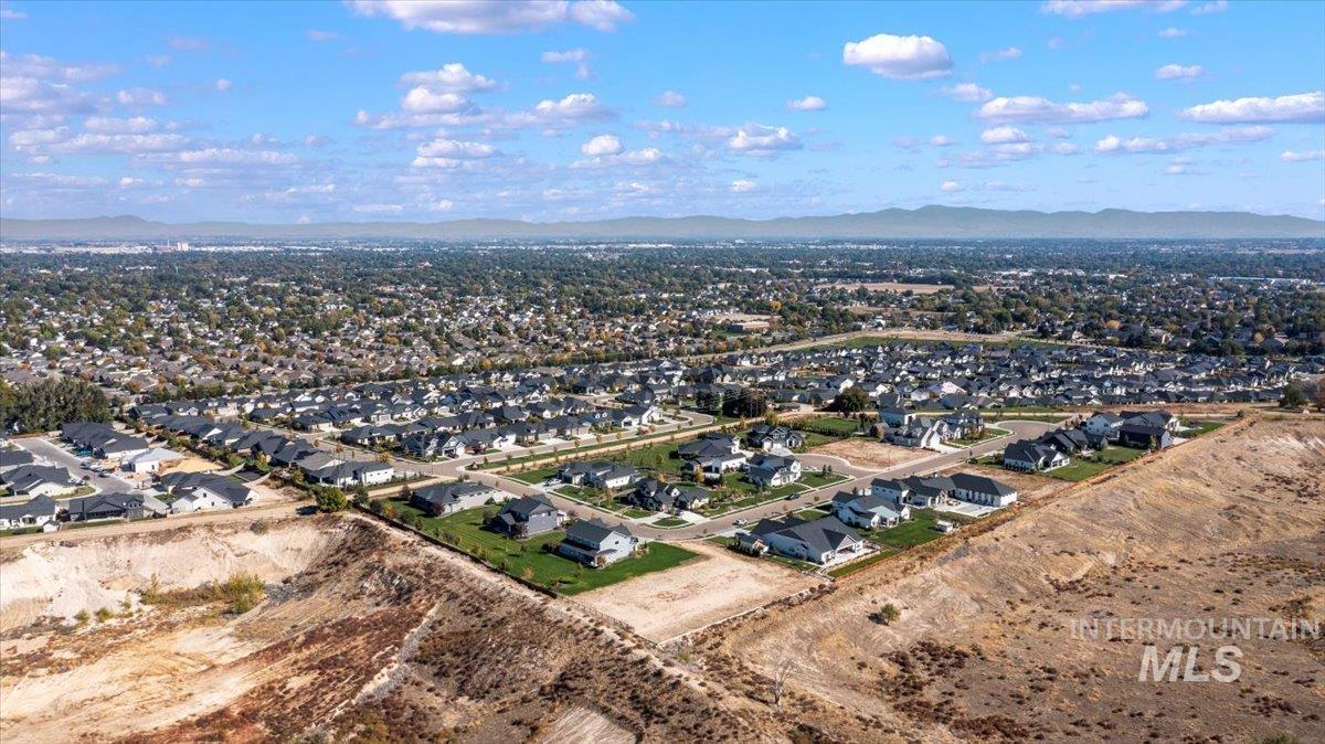 Aerial view of property's location with nearby suburban area and a mountainous background