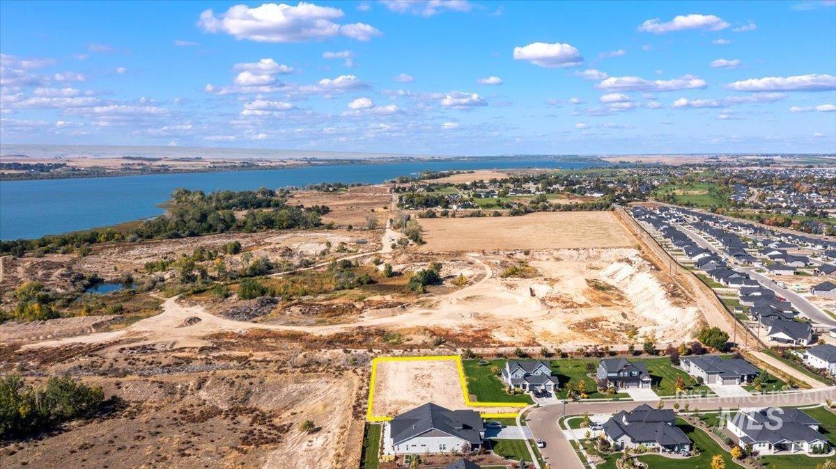 Aerial perspective of suburban area with property boundaries highlighted and a nearby body of water