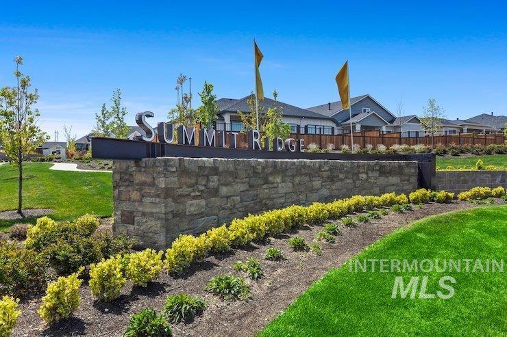 Community sign with a yard and a residential view