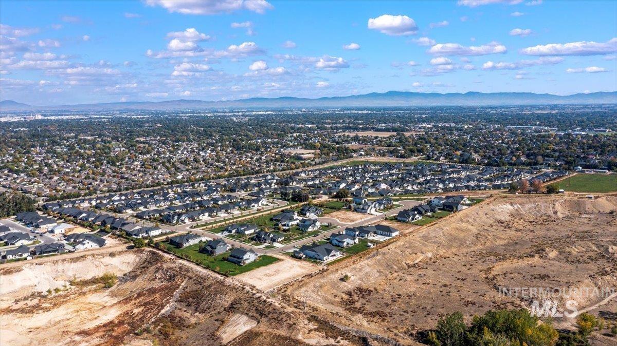 Aerial view of property's location with nearby suburban area and mountains