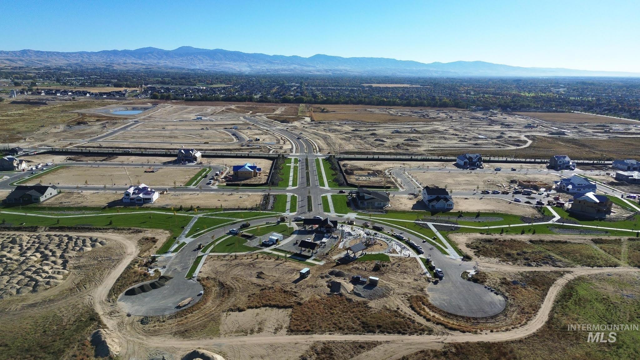 Aerial view of property and surrounding area featuring a mountain backdrop