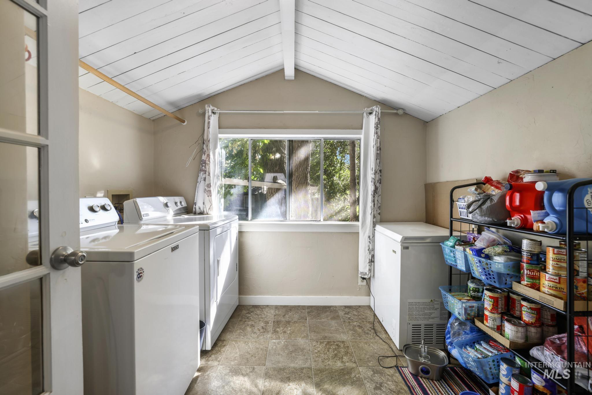 Washroom featuring independent washer and dryer and baseboards