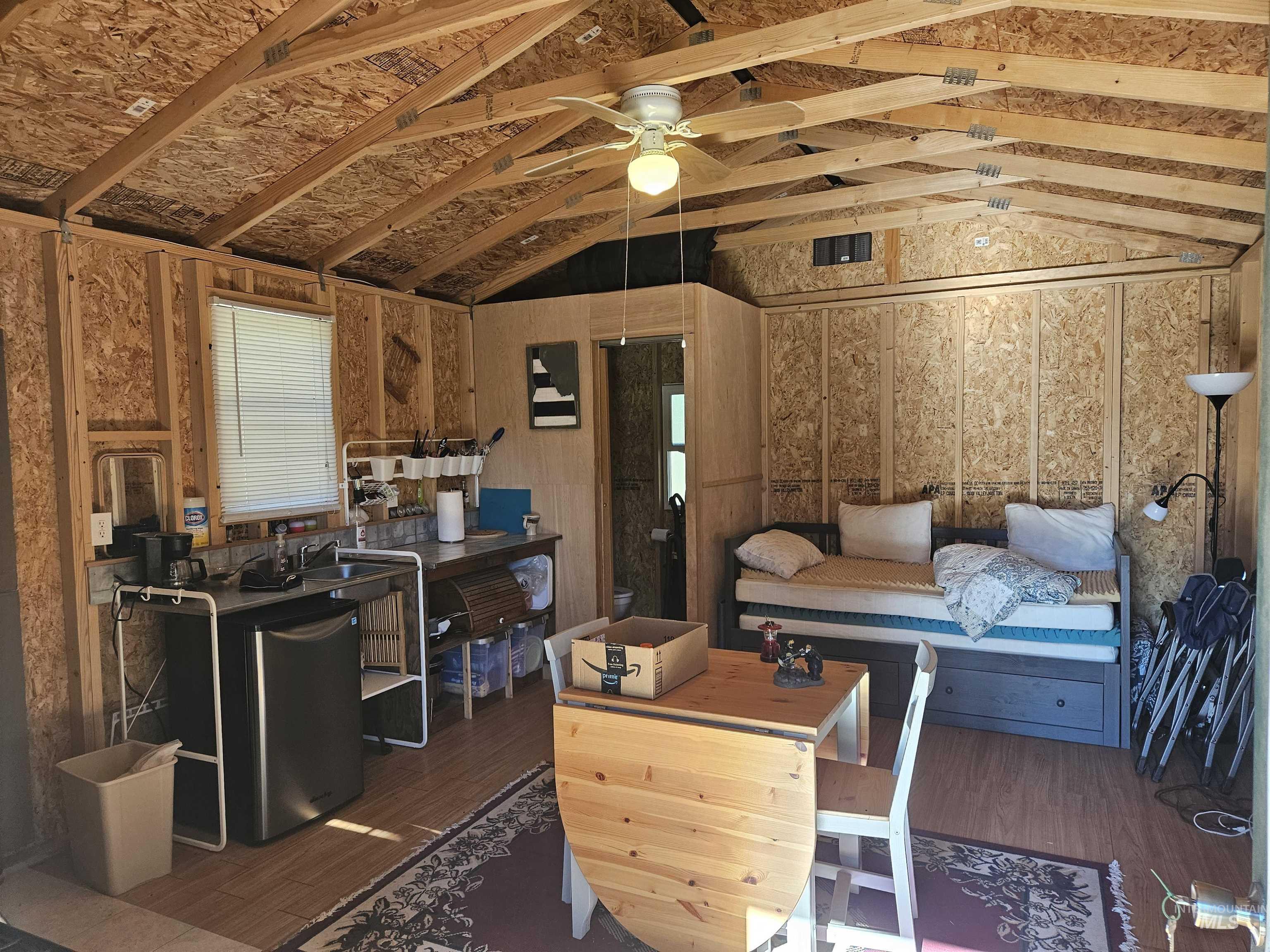 Living area featuring lofted ceiling, wood finished floors, and ceiling fan
