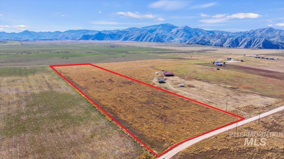 Overview of rural landscape with property boundaries highlighted and a mountain backdrop