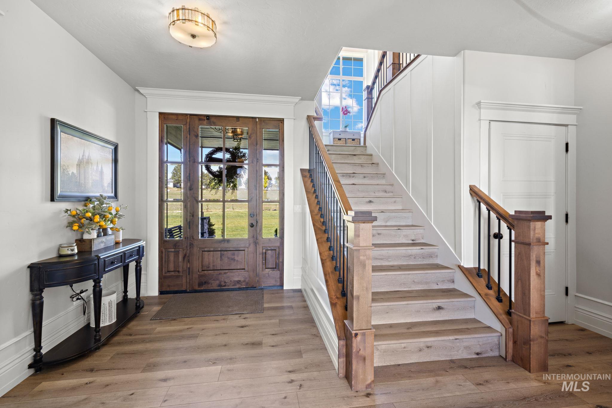 Entryway featuring healthy amount of natural light, light wood-type flooring, and stairs