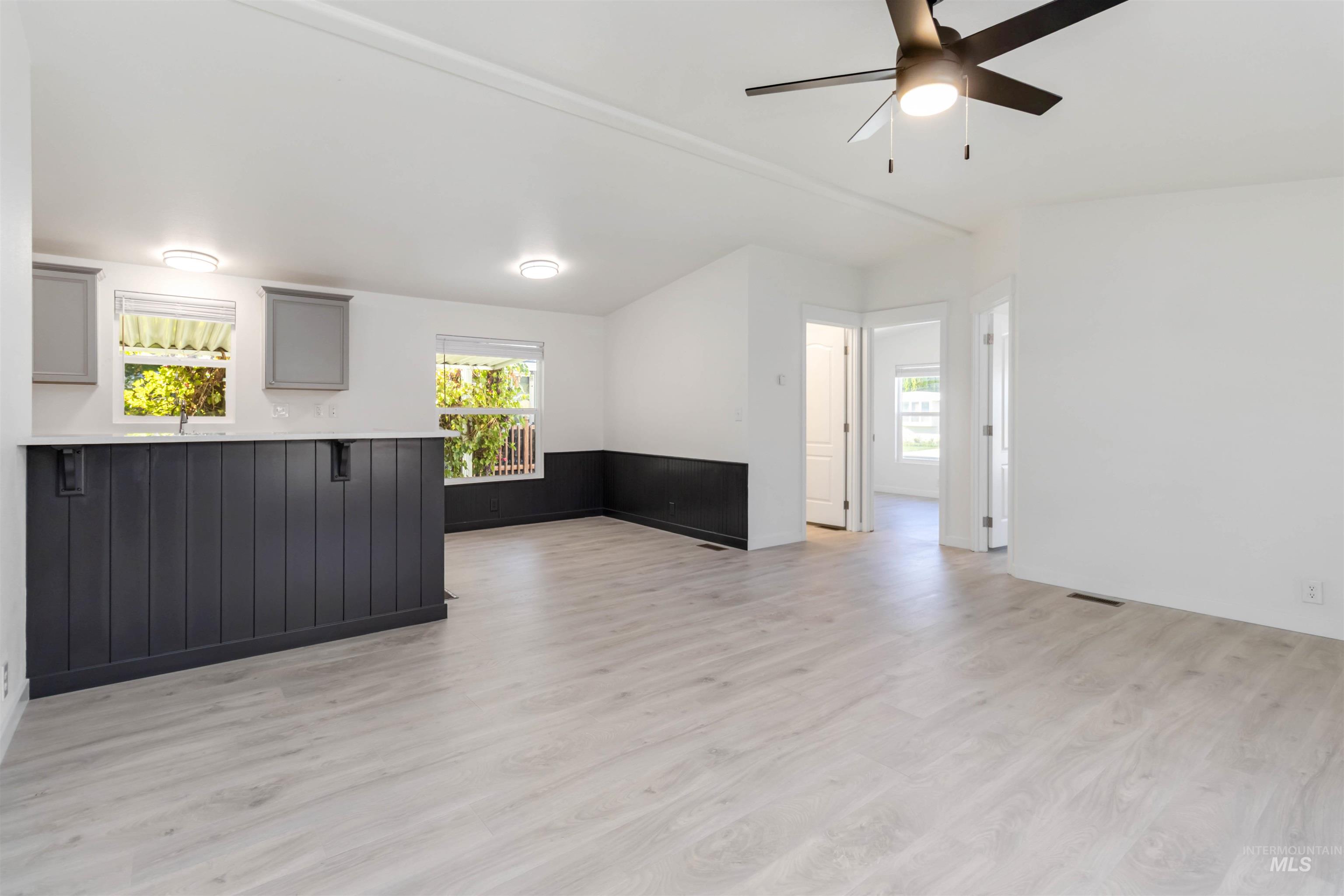 Unfurnished living room featuring light wood-type flooring and a ceiling fan