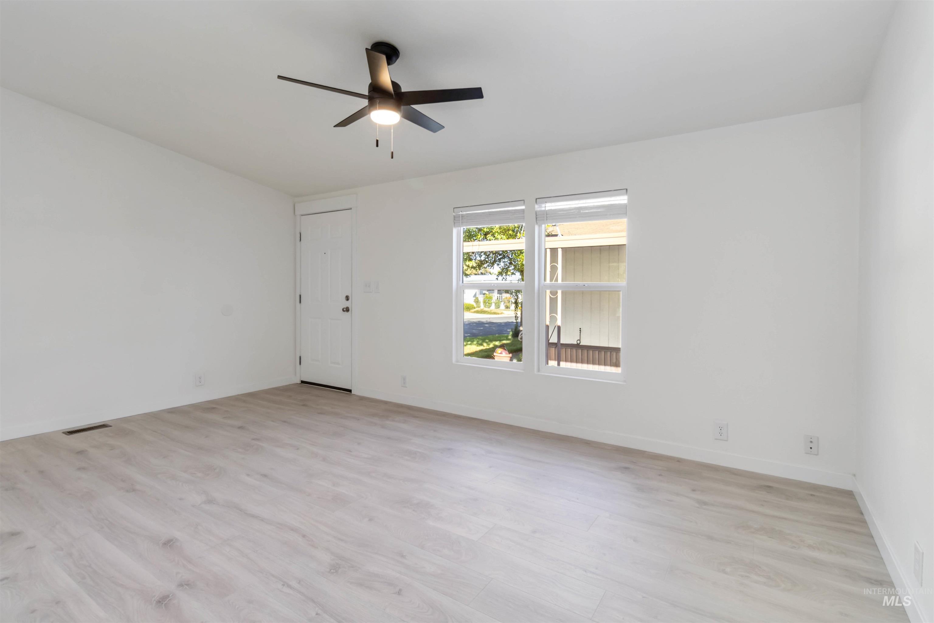 Unfurnished room with light wood-style floors and a ceiling fan