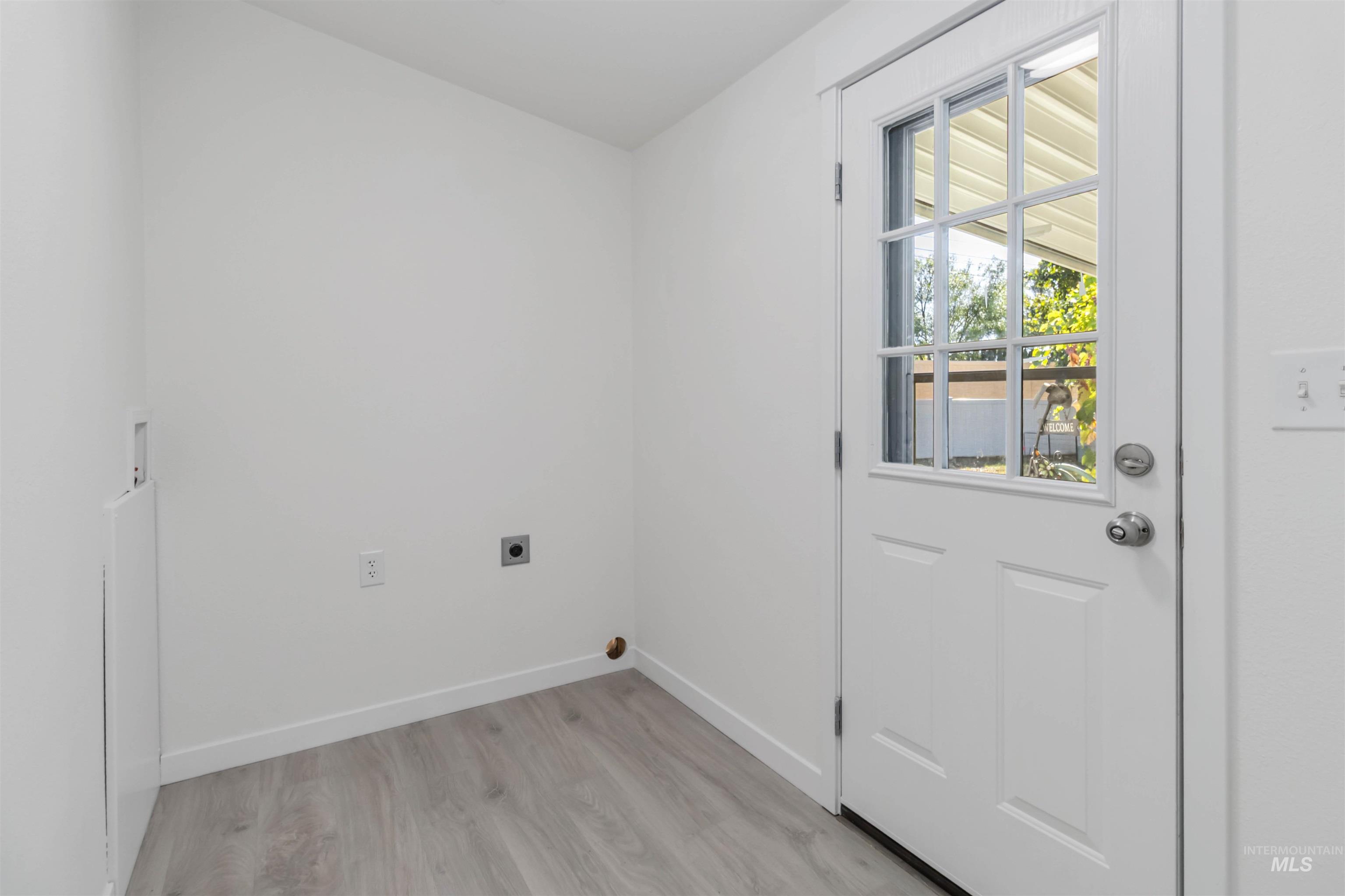 Washroom featuring light wood finished floors, hookup for an electric dryer, and washer hookup