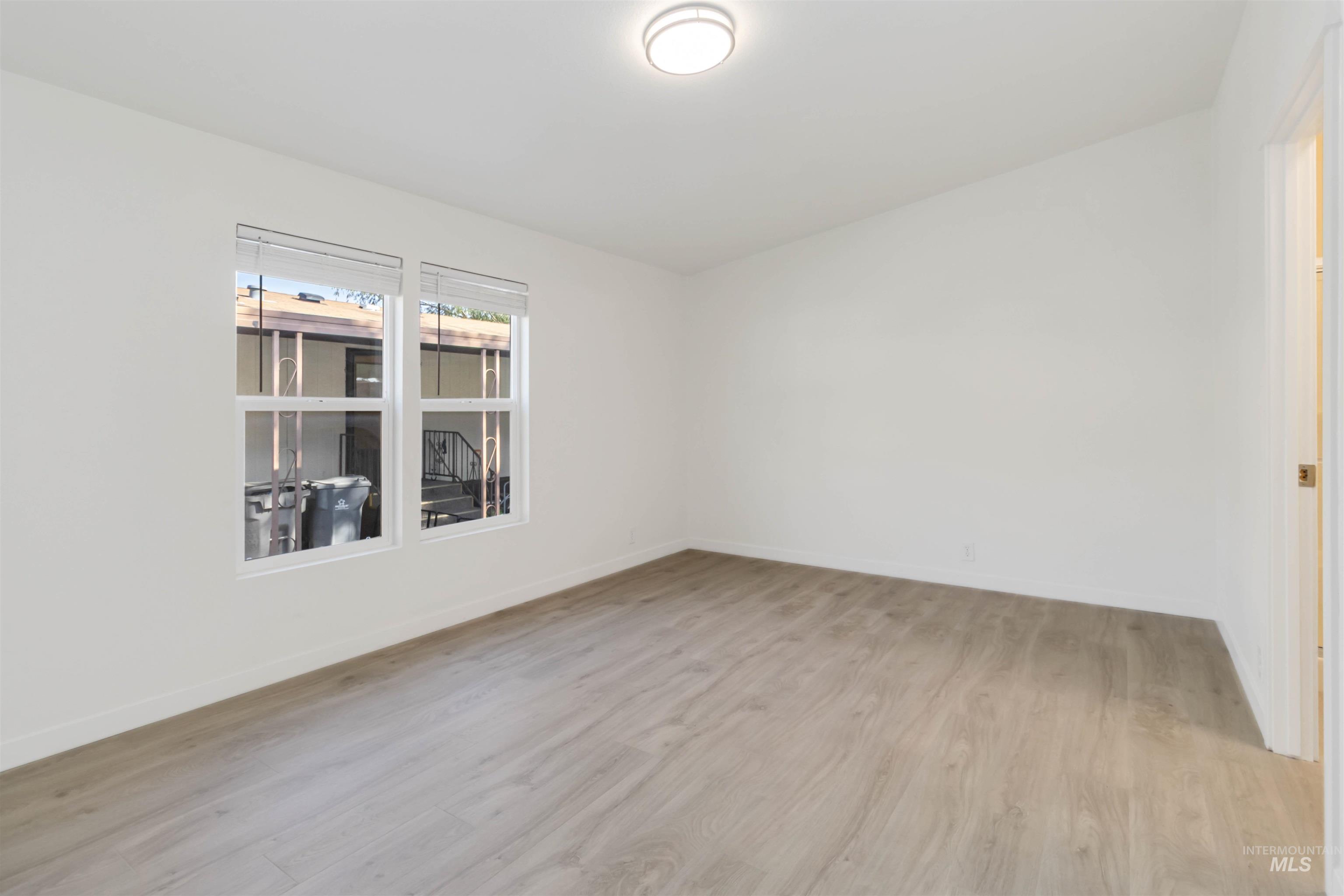 Unfurnished room featuring light wood-type flooring and baseboards