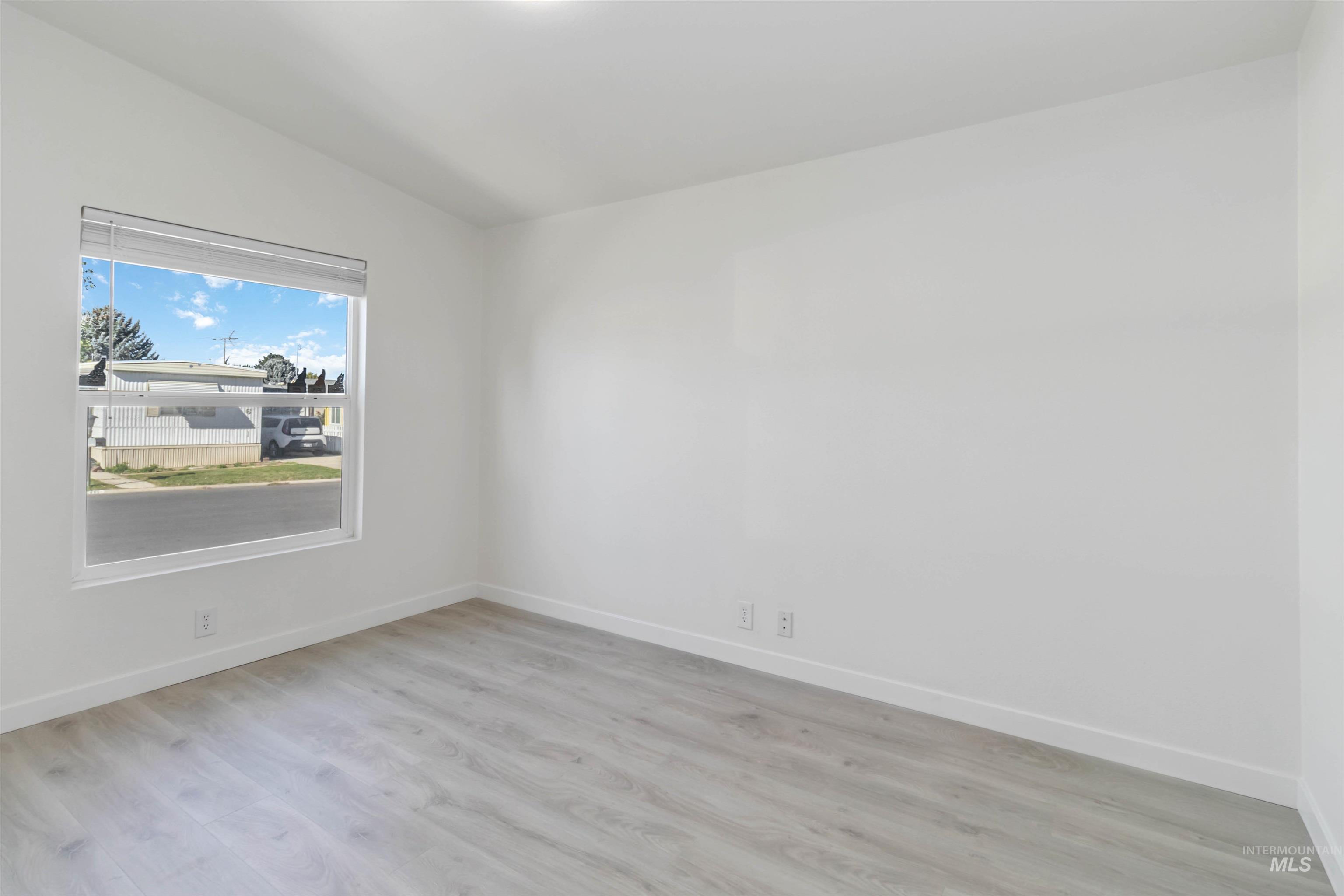 Empty room featuring light wood finished floors and baseboards