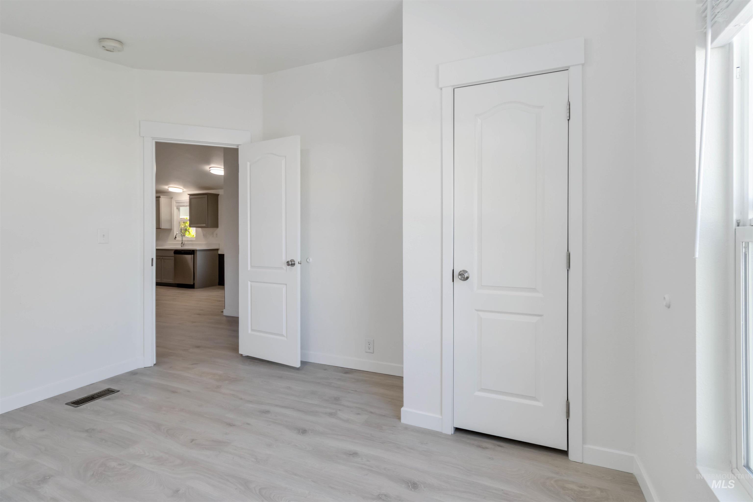 Unfurnished bedroom featuring light wood finished floors and baseboards