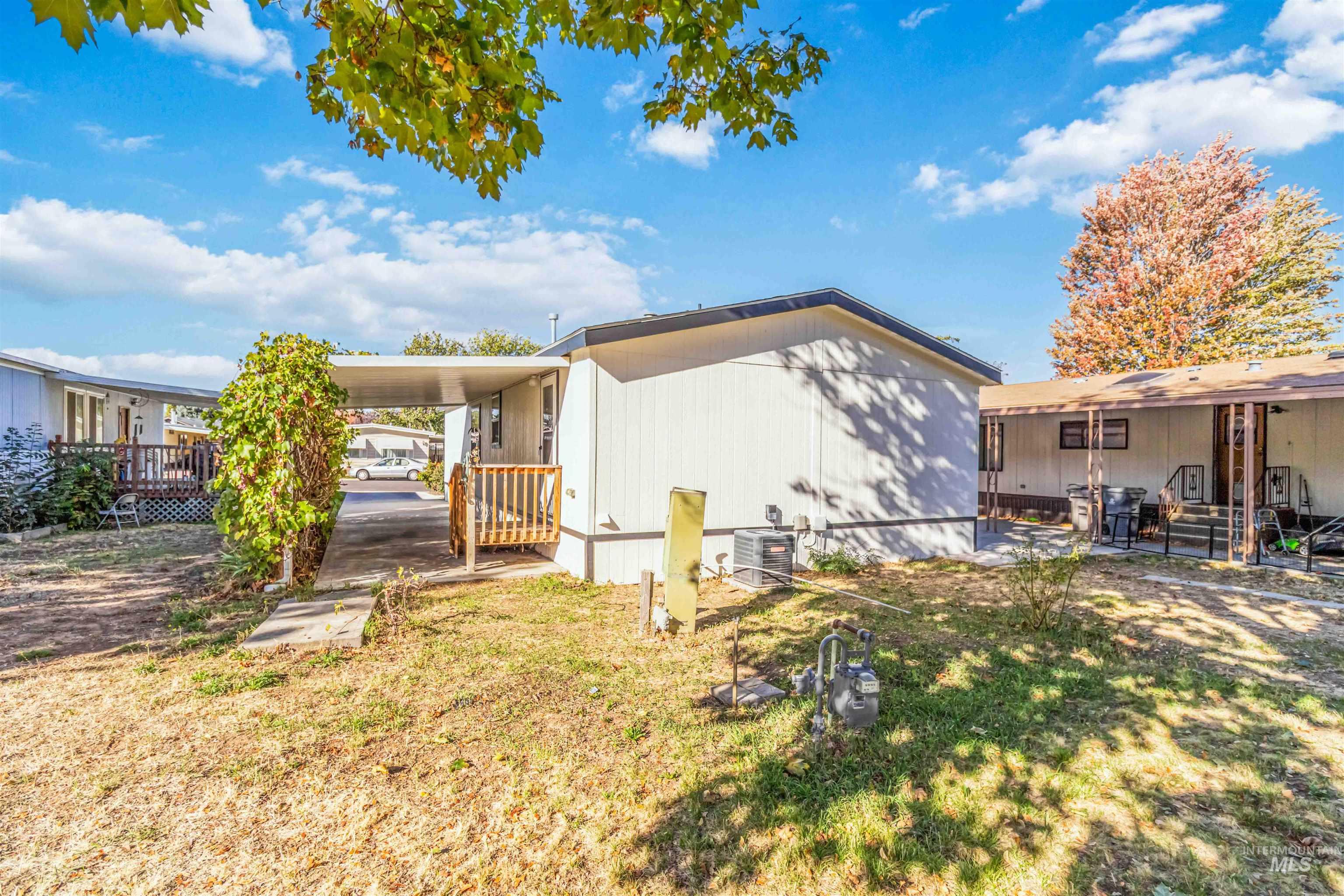 Rear view of property featuring a carport and a lawn