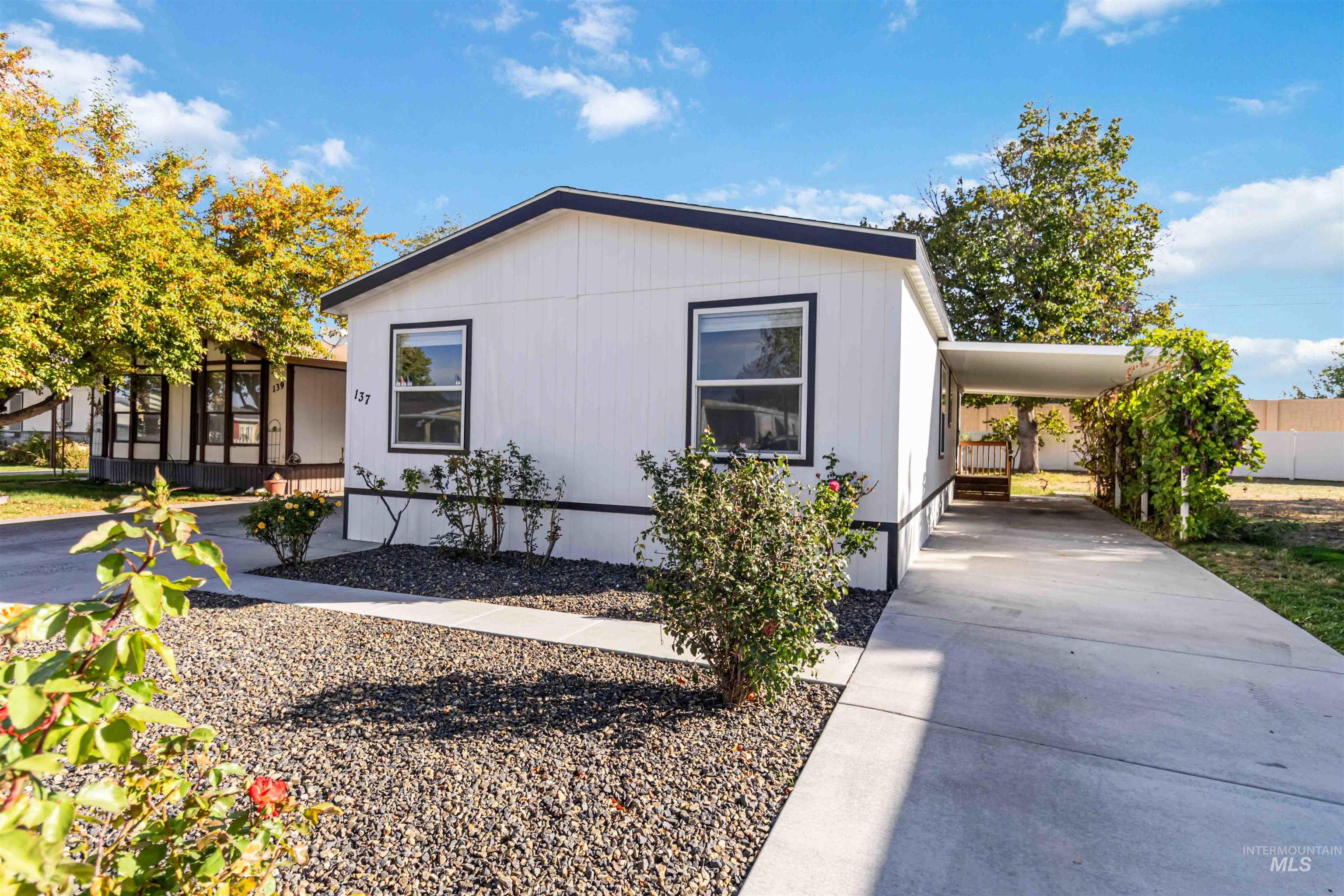 View of front facade with an attached carport and driveway