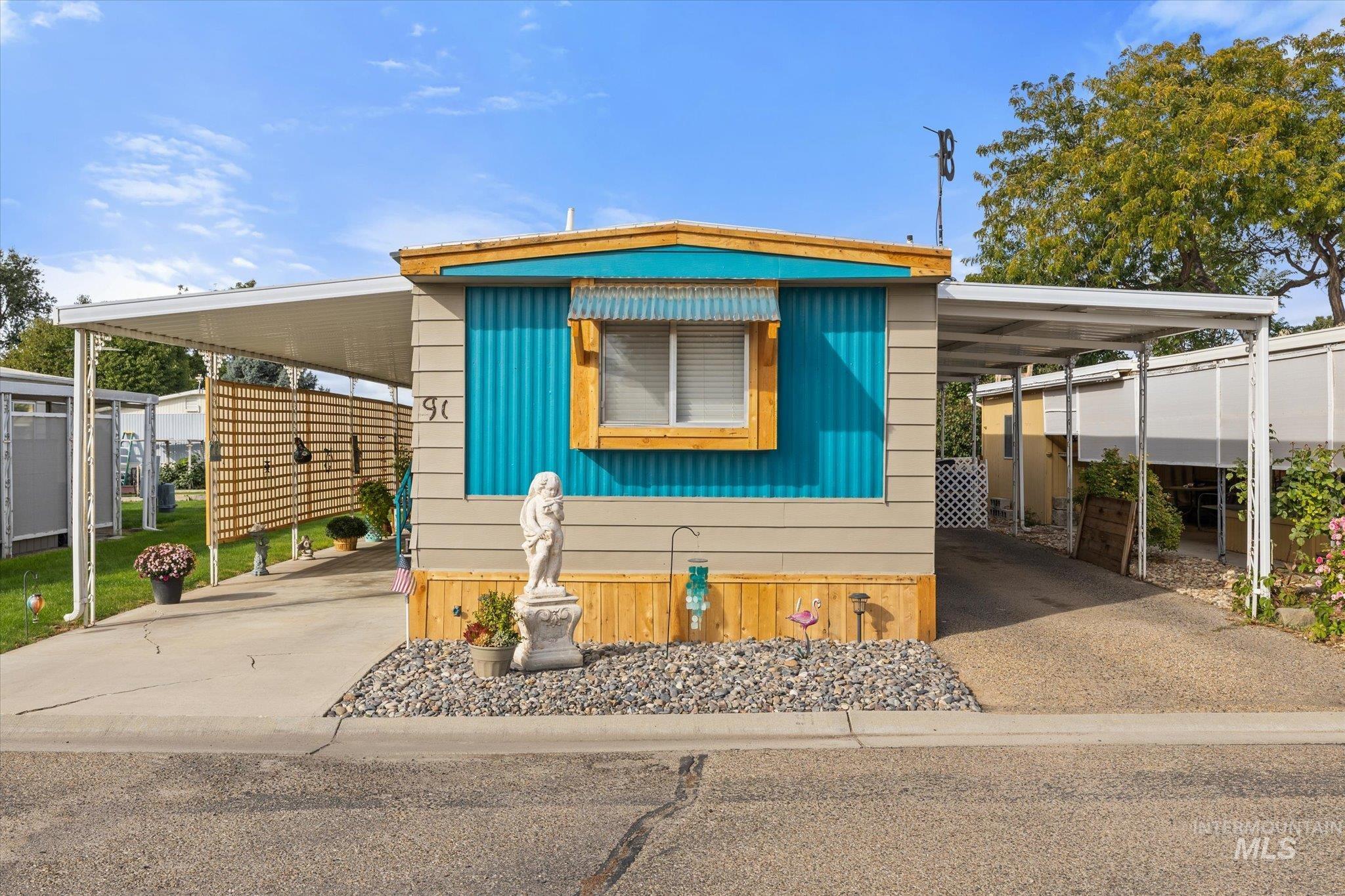 Manufactured / mobile home featuring an attached carport and concrete driveway