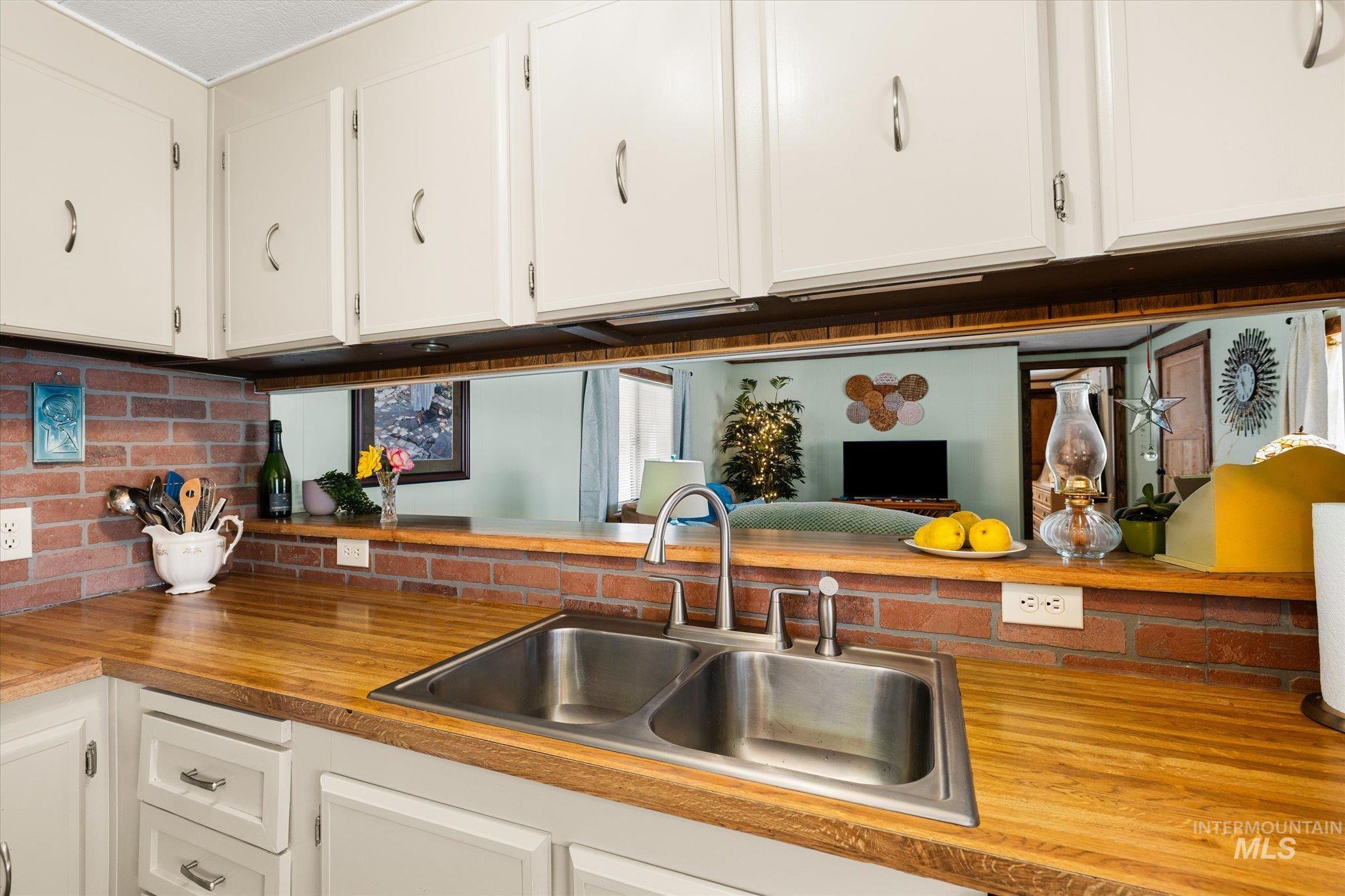 Kitchen featuring wooden counters and white cabinets