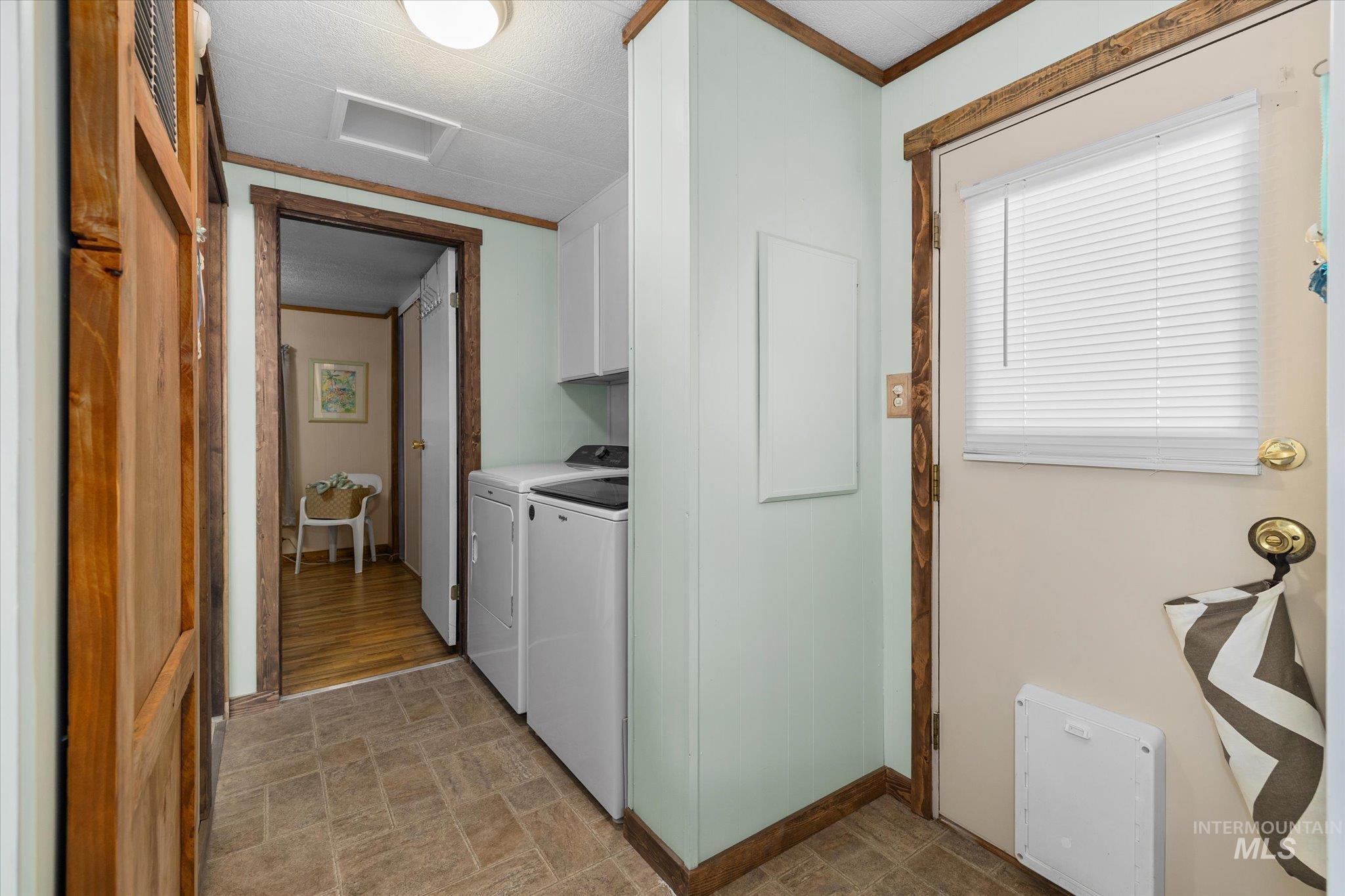 Laundry area with cabinet space, washer and dryer, and crown molding