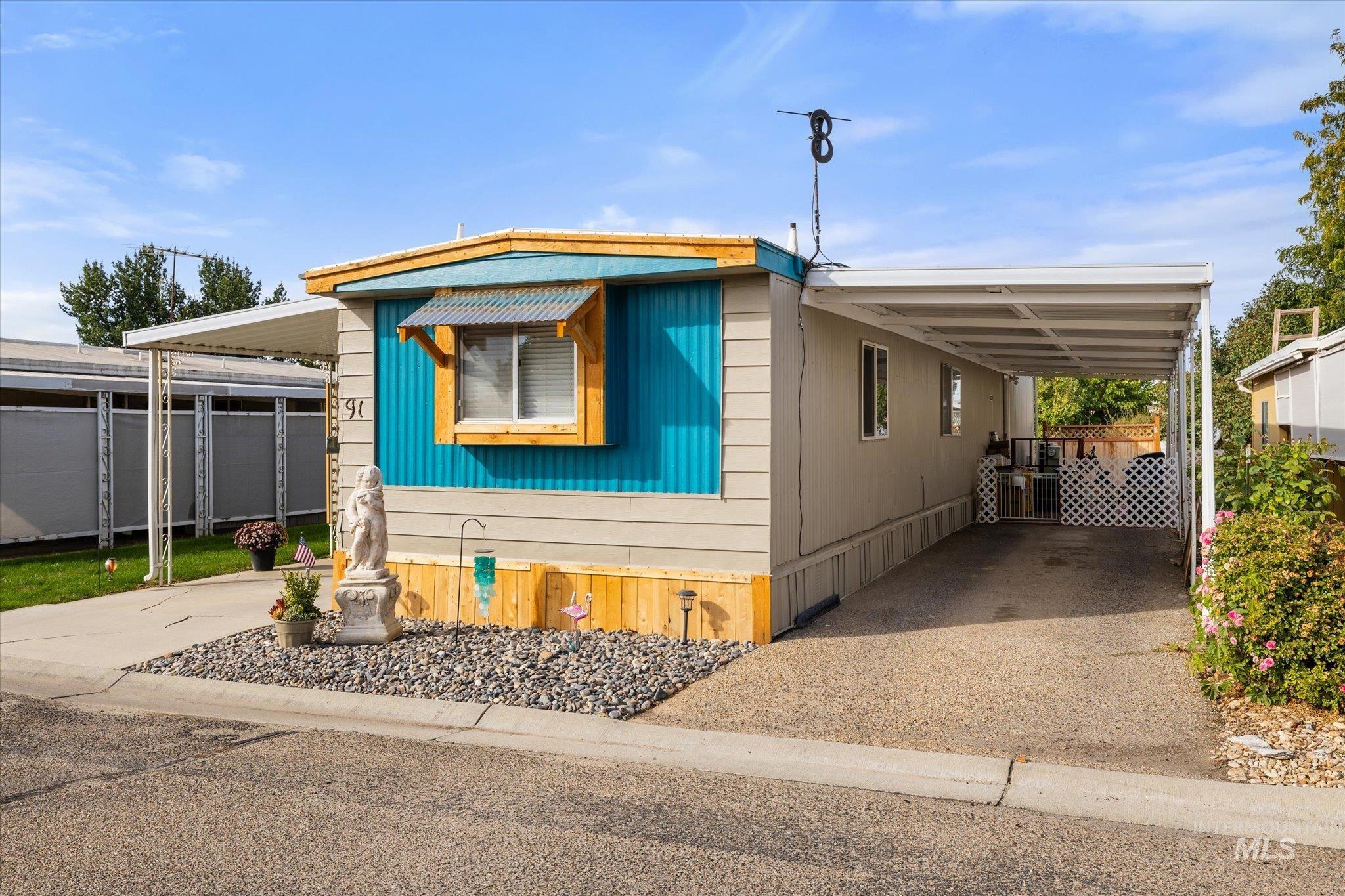 Manufactured / mobile home featuring an attached carport and concrete driveway