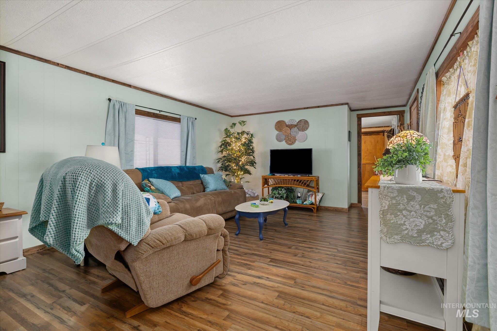 Living room with wood finished floors and crown molding