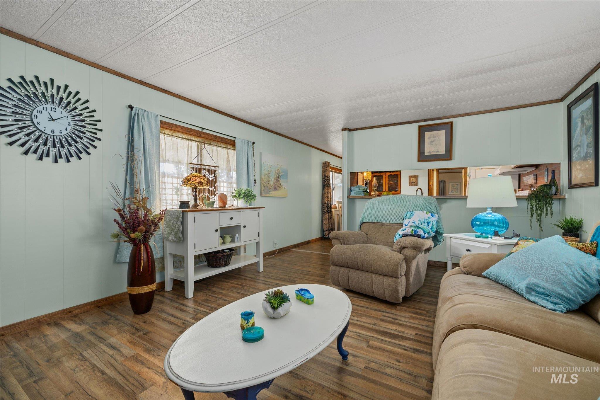 Living room with crown molding and wood finished floors