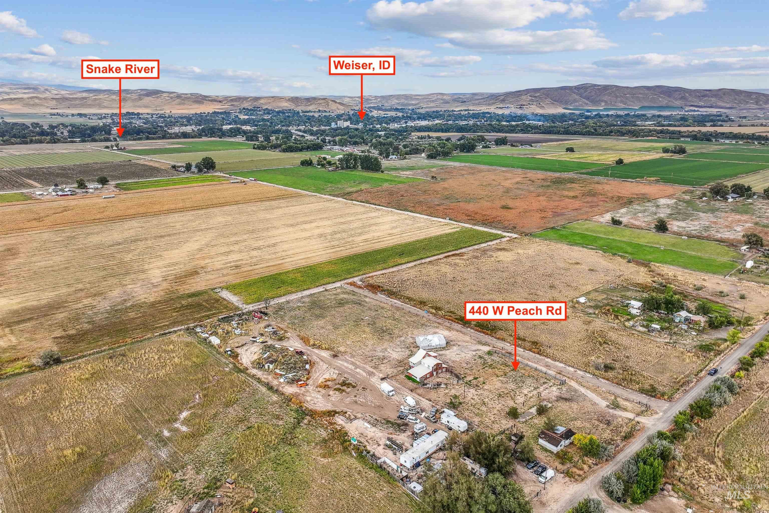 Aerial view of property and surrounding area featuring a mountain backdrop and rural landscape