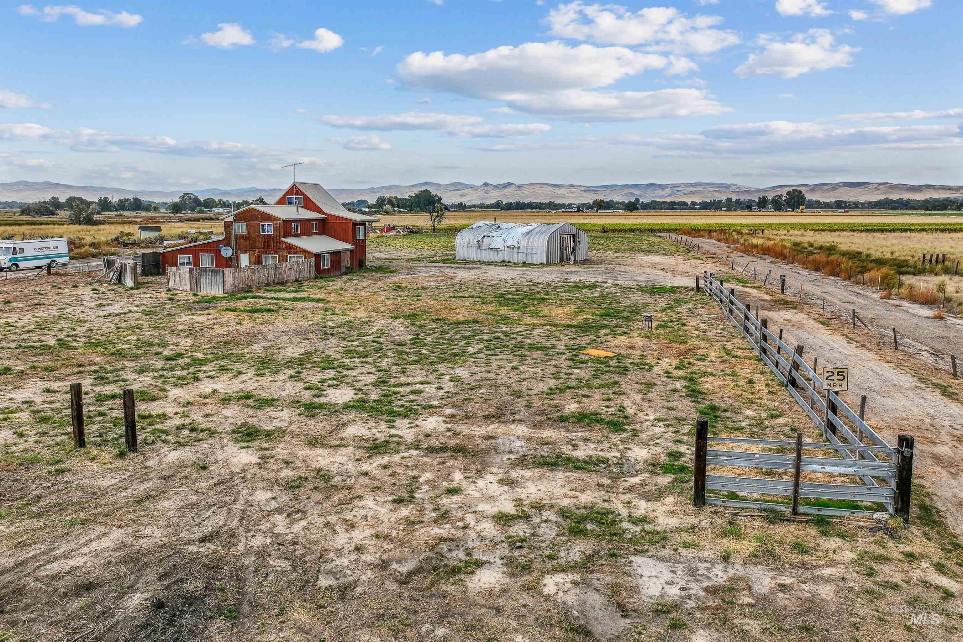 View of yard featuring a rural view, an outbuilding, a mountain view, and a barn