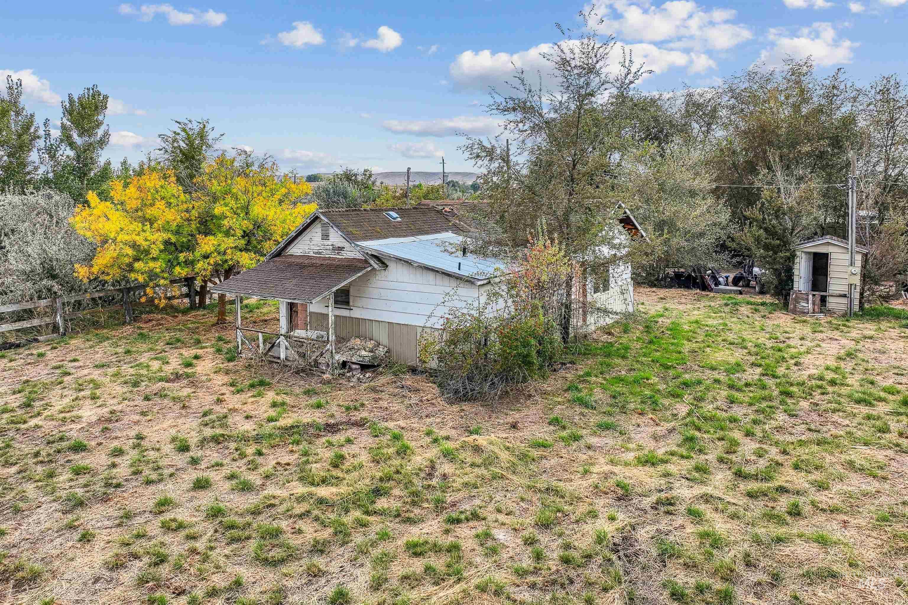 View of side of property featuring a shingled roof and an outdoor structure