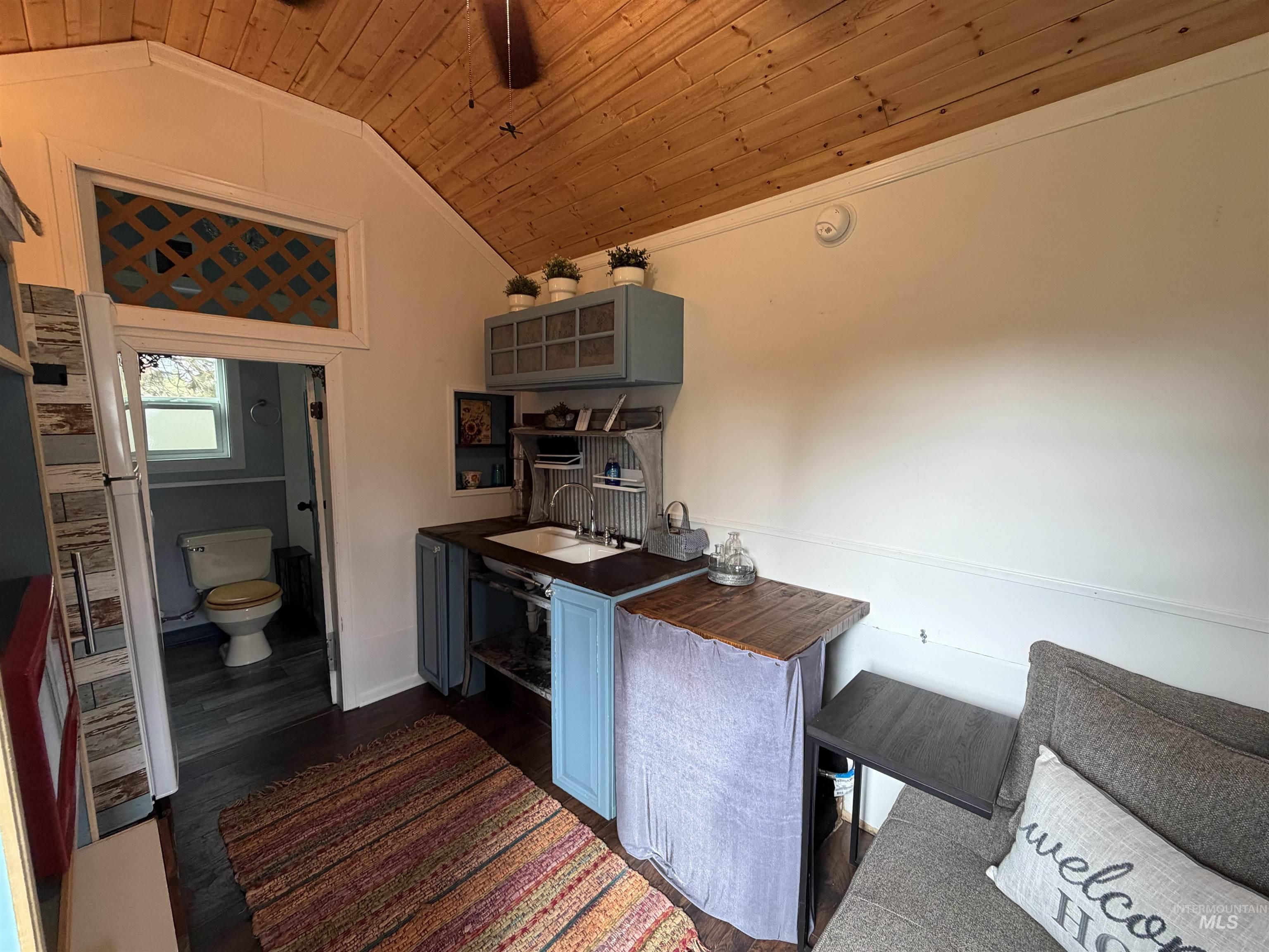 Kitchen featuring wooden ceiling, dark wood finished floors, lofted ceiling, ornamental molding, and open shelves