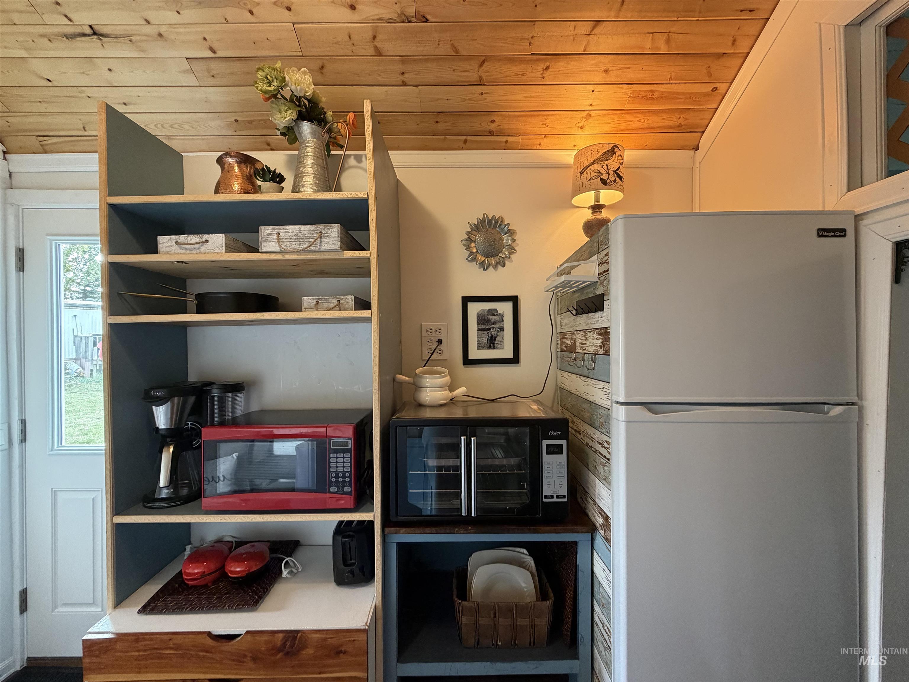 Kitchen with freestanding refrigerator and wooden ceiling