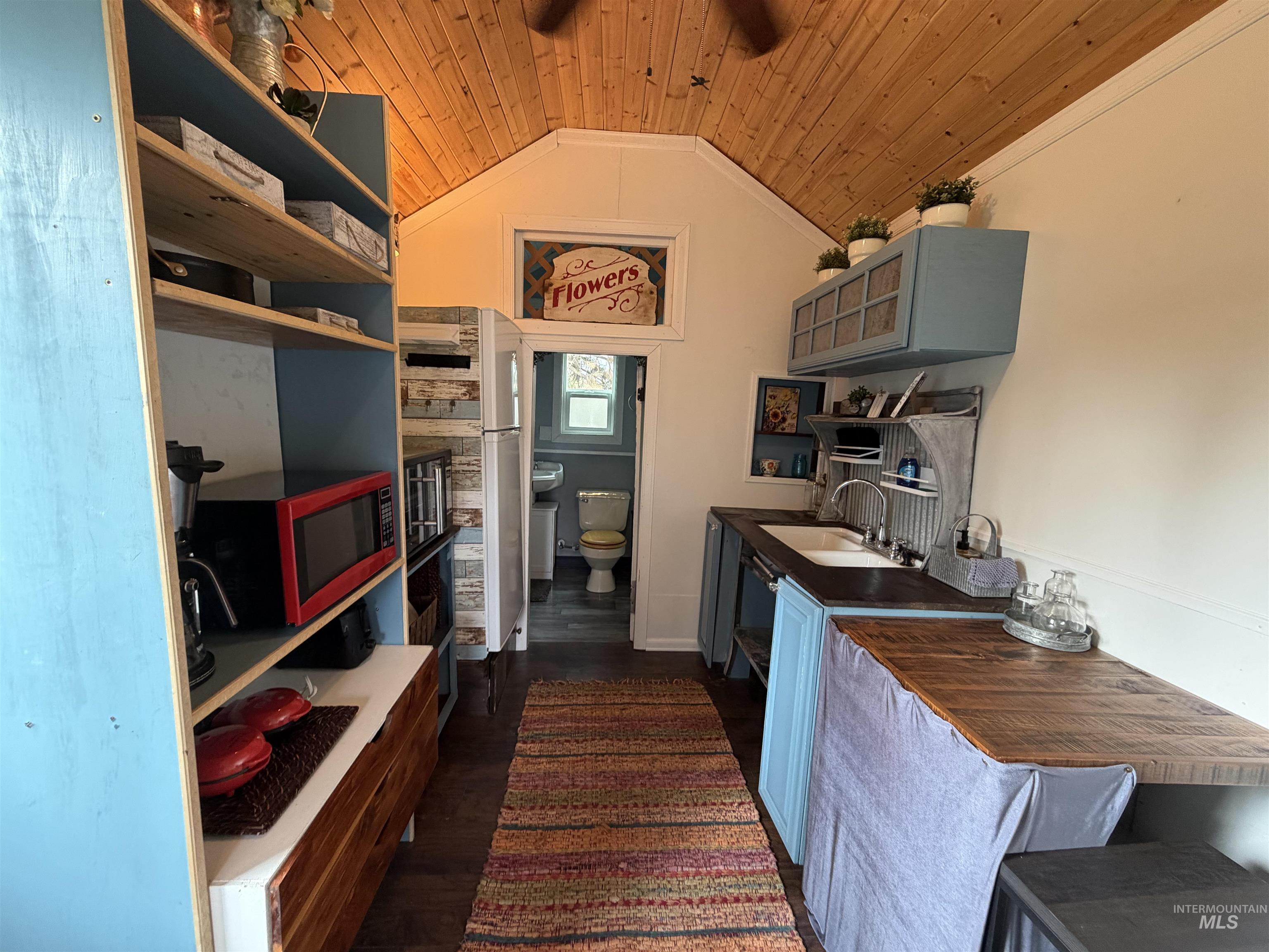 Kitchen featuring dark wood-type flooring, vaulted ceiling, wood ceiling, blue cabinets, and gray cabinetry