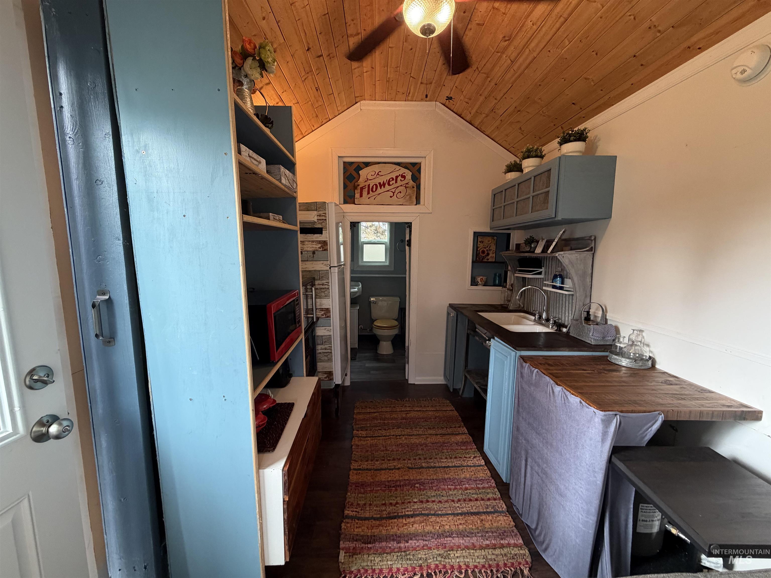 Kitchen featuring wood ceiling, lofted ceiling, dark wood-type flooring, gray cabinetry, and ceiling fan