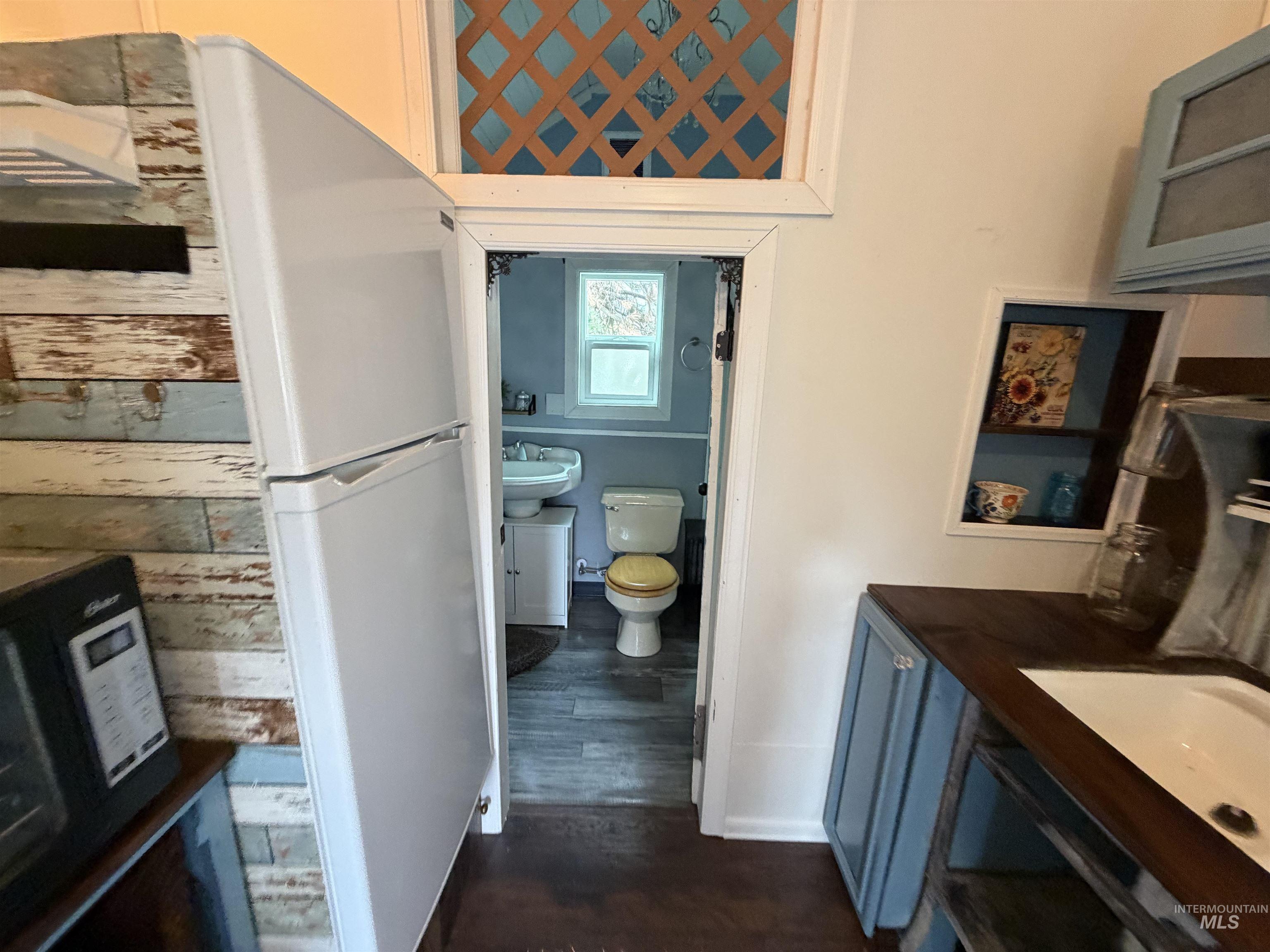 Bathroom with dark wood-style floors and wood walls