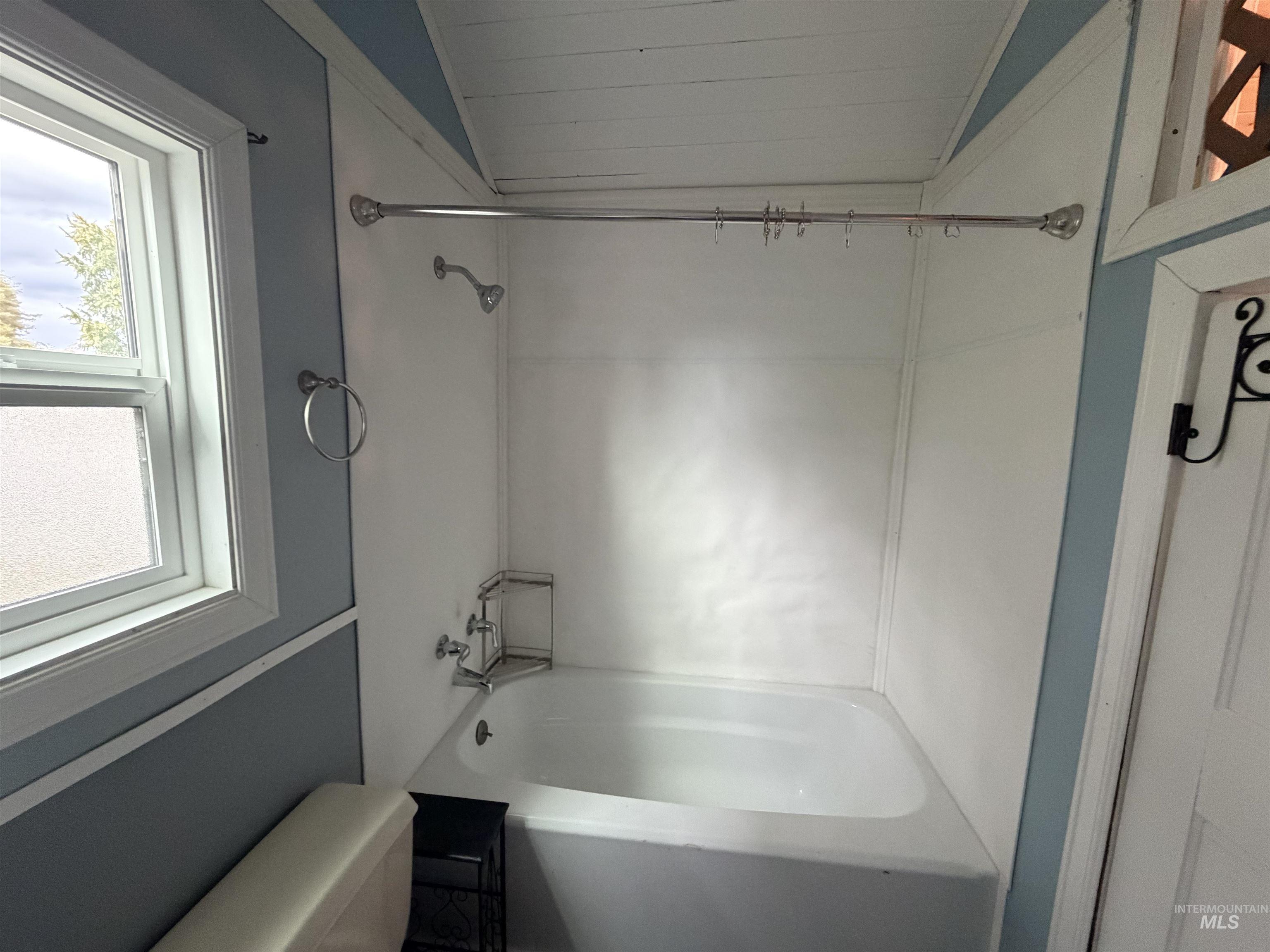 Full bathroom with bathtub / shower combination and vaulted ceiling
