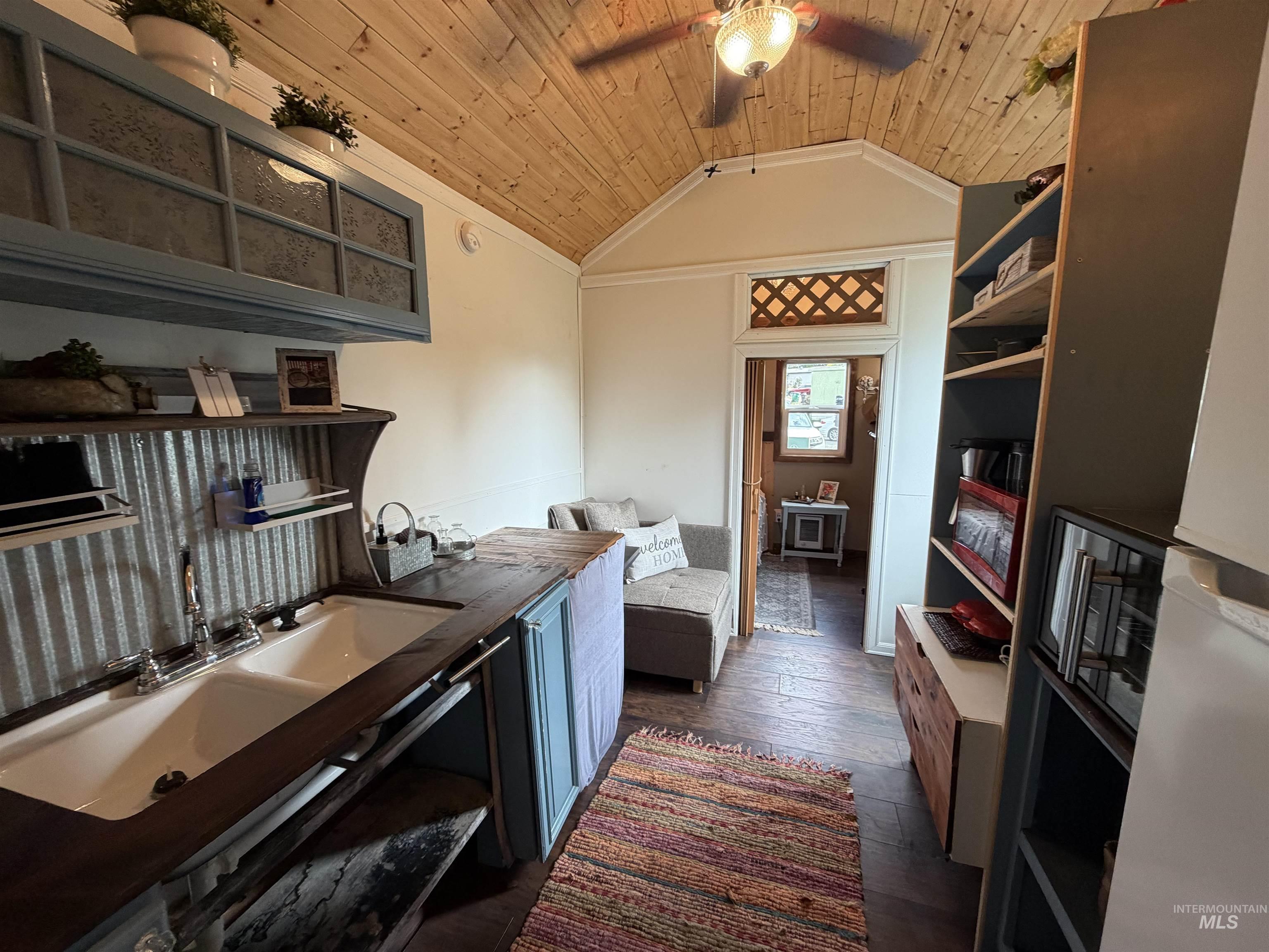 Kitchen featuring wood ceiling, lofted ceiling, dark wood finished floors, open shelves, and ceiling fan