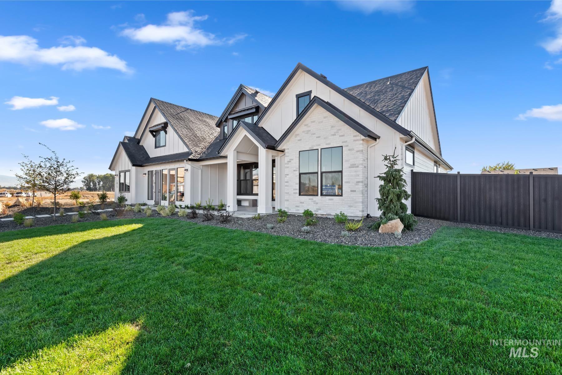 Modern farmhouse featuring board and batten siding, brick siding, and roof with shingles