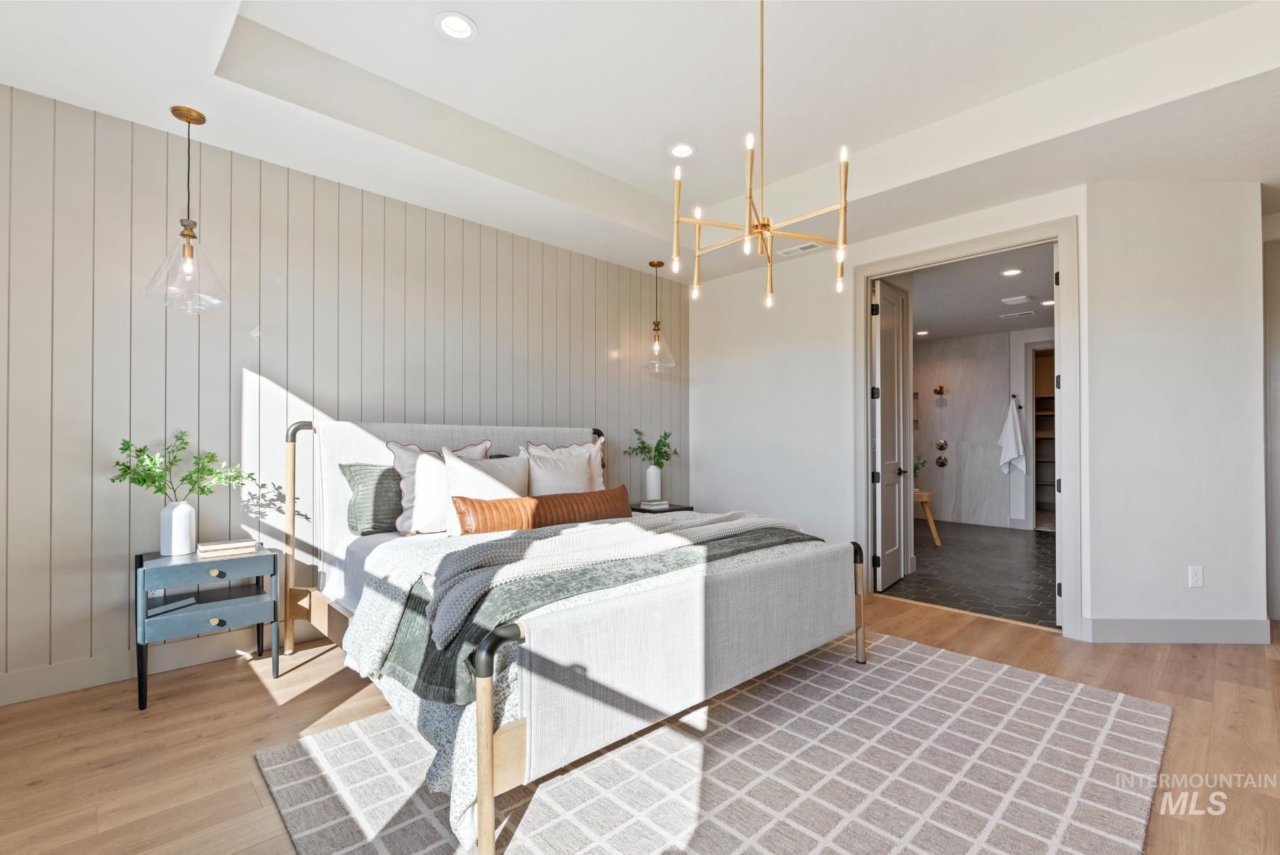 Bedroom featuring a chandelier, light wood-style flooring, recessed lighting, connected bathroom, and wood walls