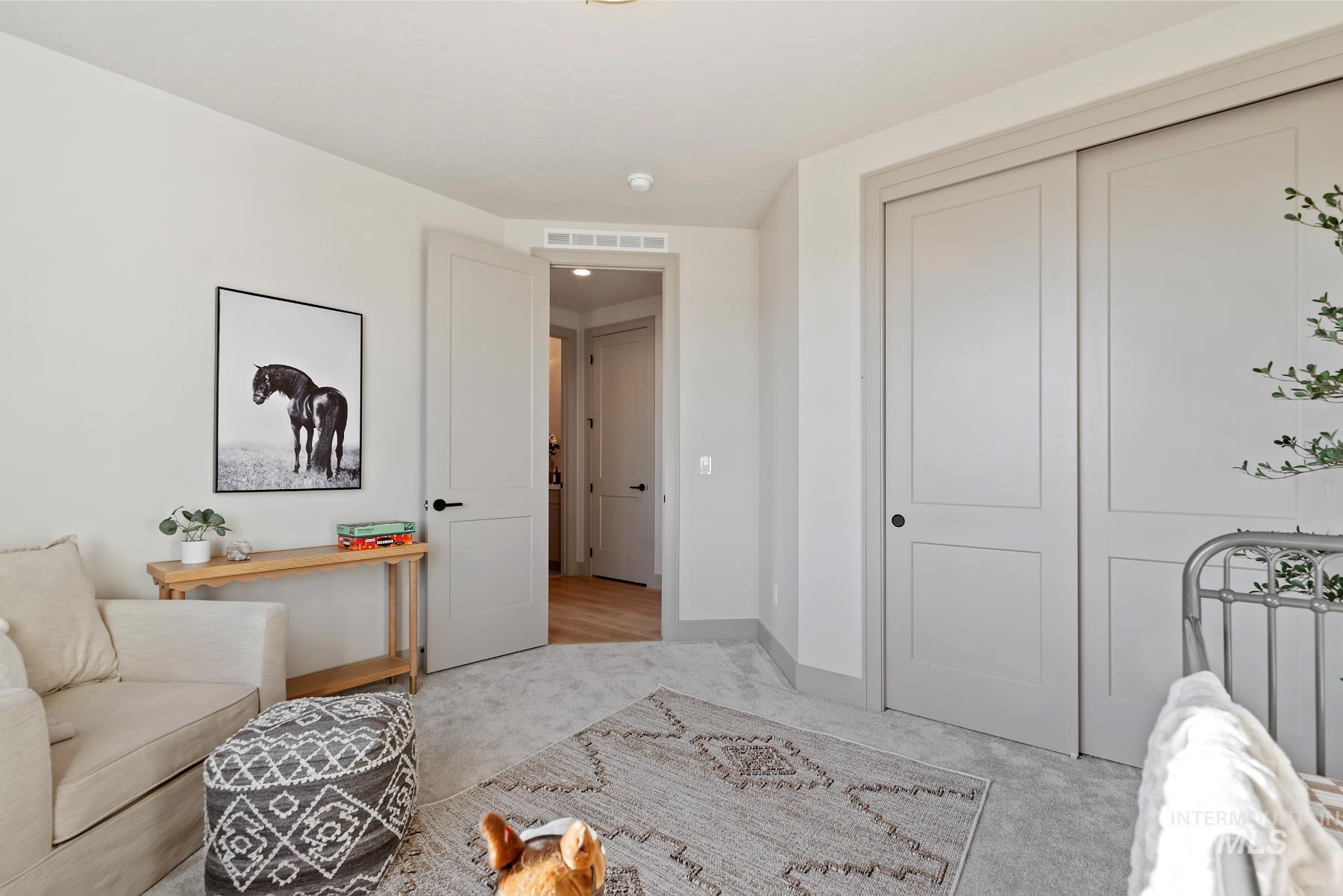 Bedroom with light colored carpet and a closet