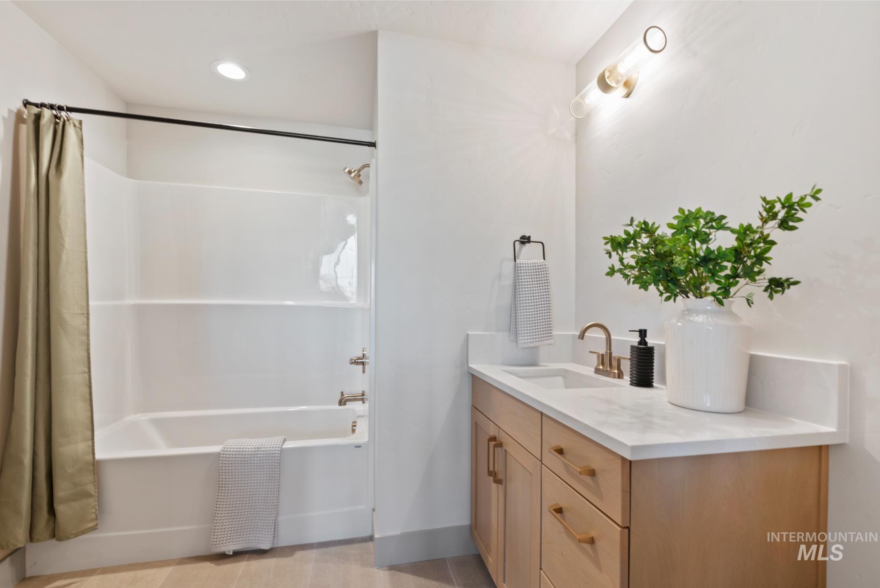 Full bath with shower / bath combo with shower curtain, vanity, light tile patterned floors, and recessed lighting