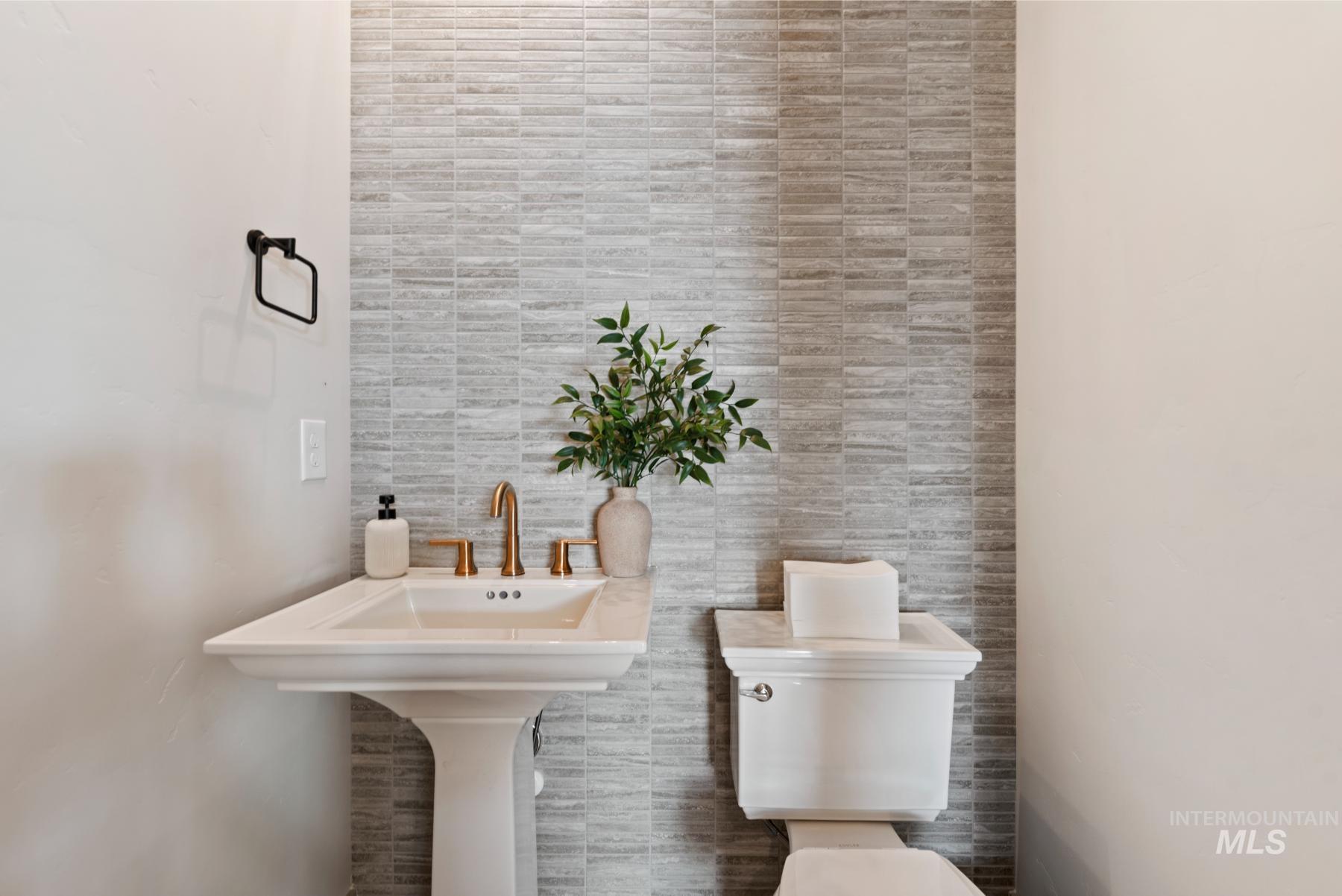 Bathroom featuring toilet and tile walls
