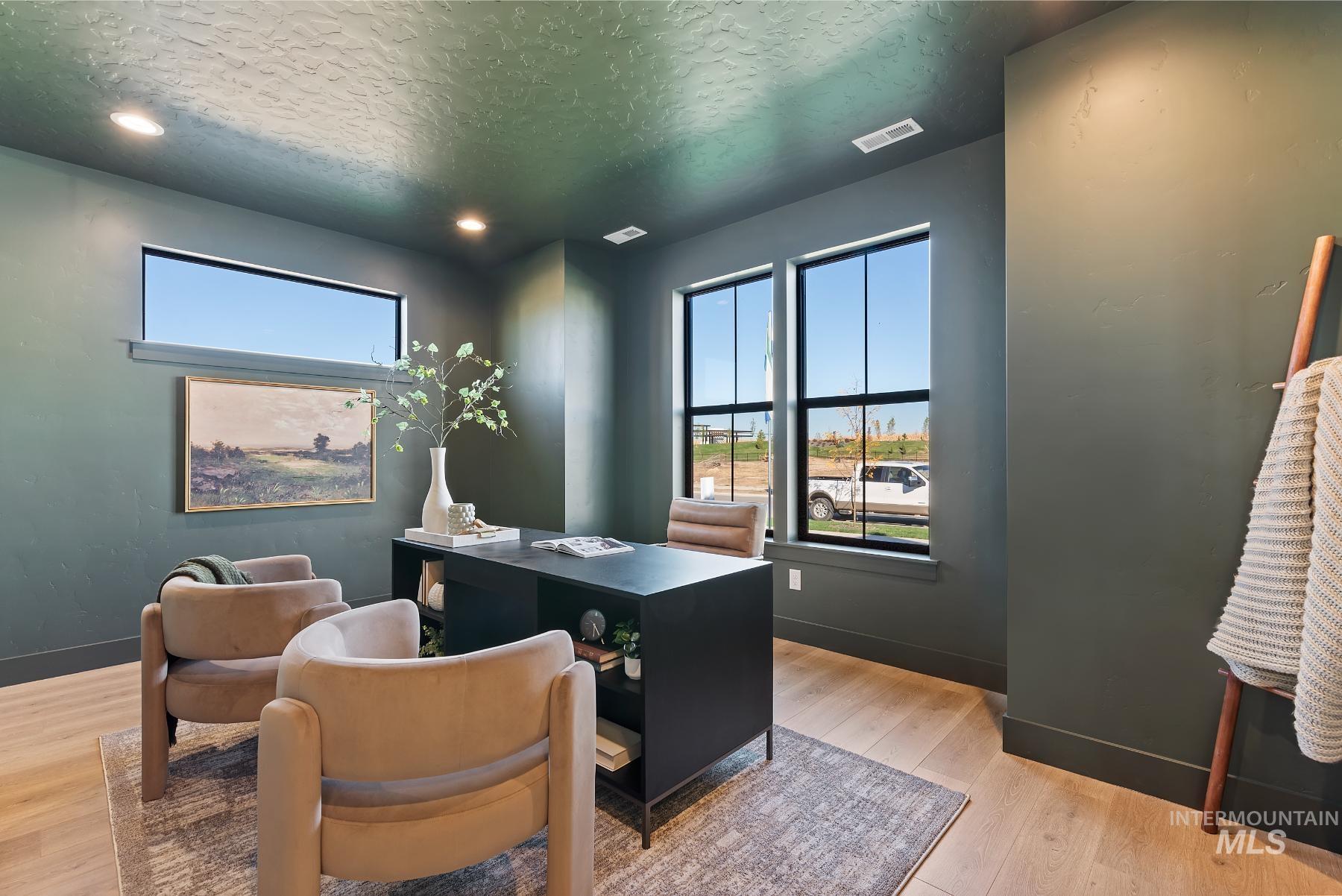 Home office featuring light wood-style flooring, a textured ceiling, and recessed lighting