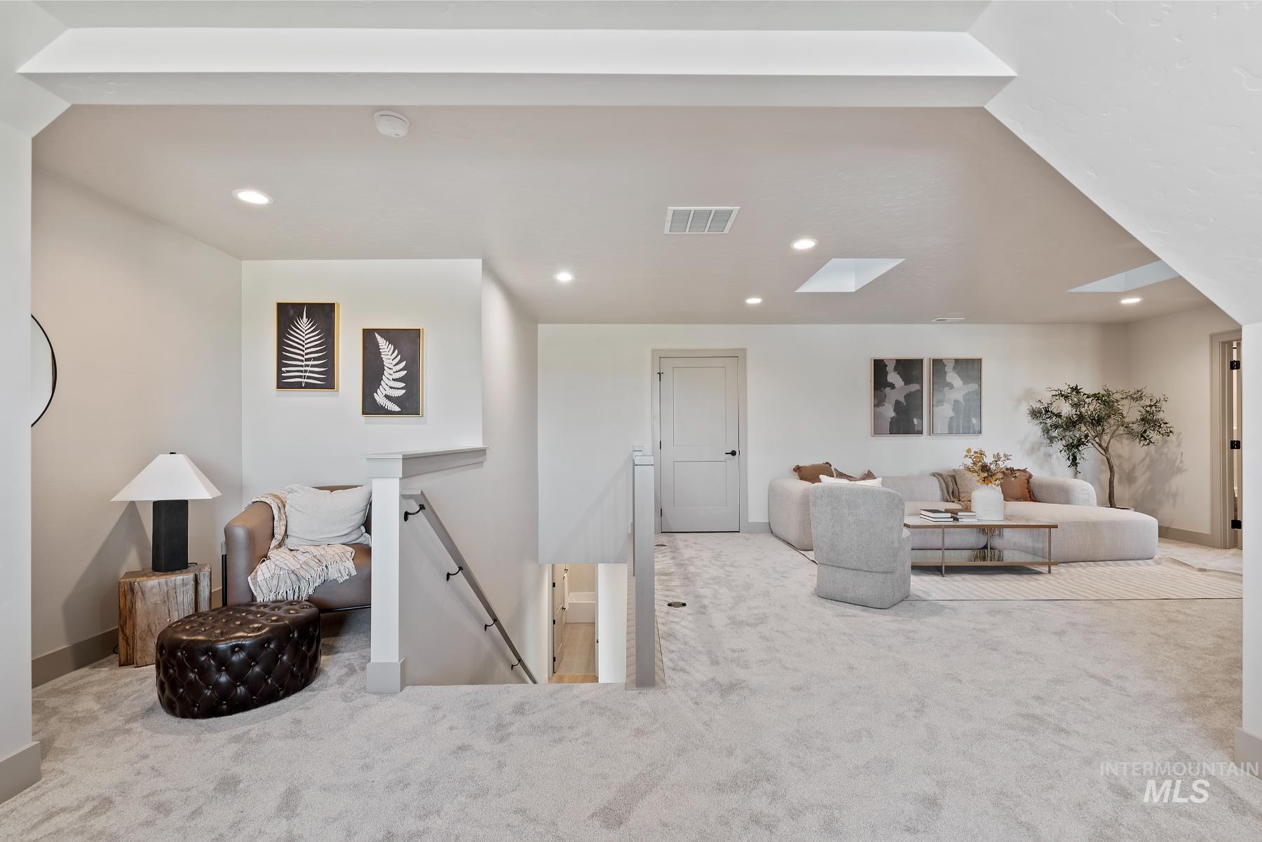 Carpeted living area featuring recessed lighting and a skylight