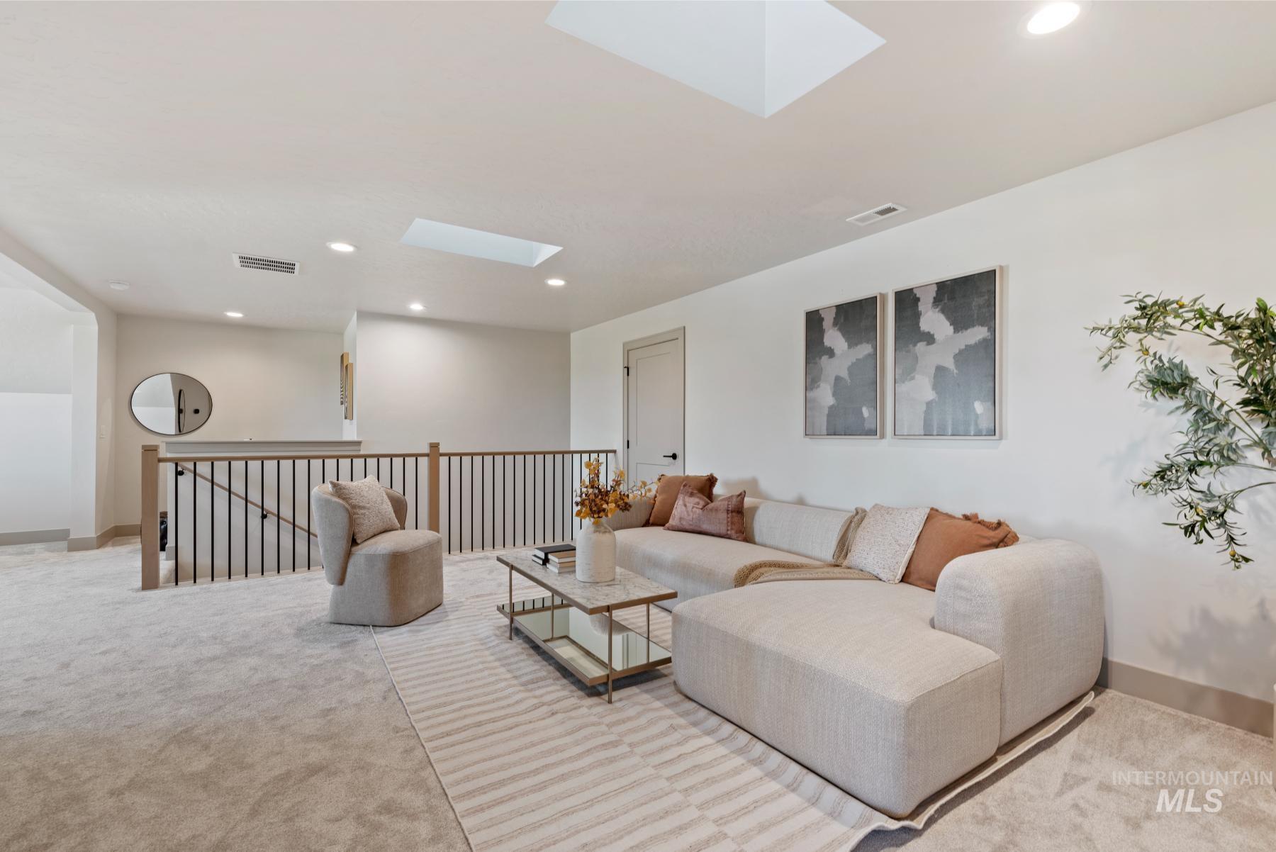 Living area featuring a skylight, recessed lighting, and light colored carpet